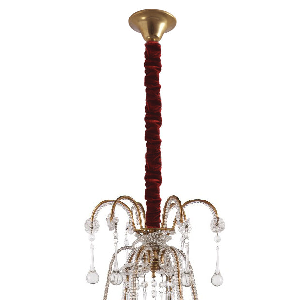 Chaussette de lustre en velours bordeaux recouvrant la tige au-dessus d'un lustre à pampilles