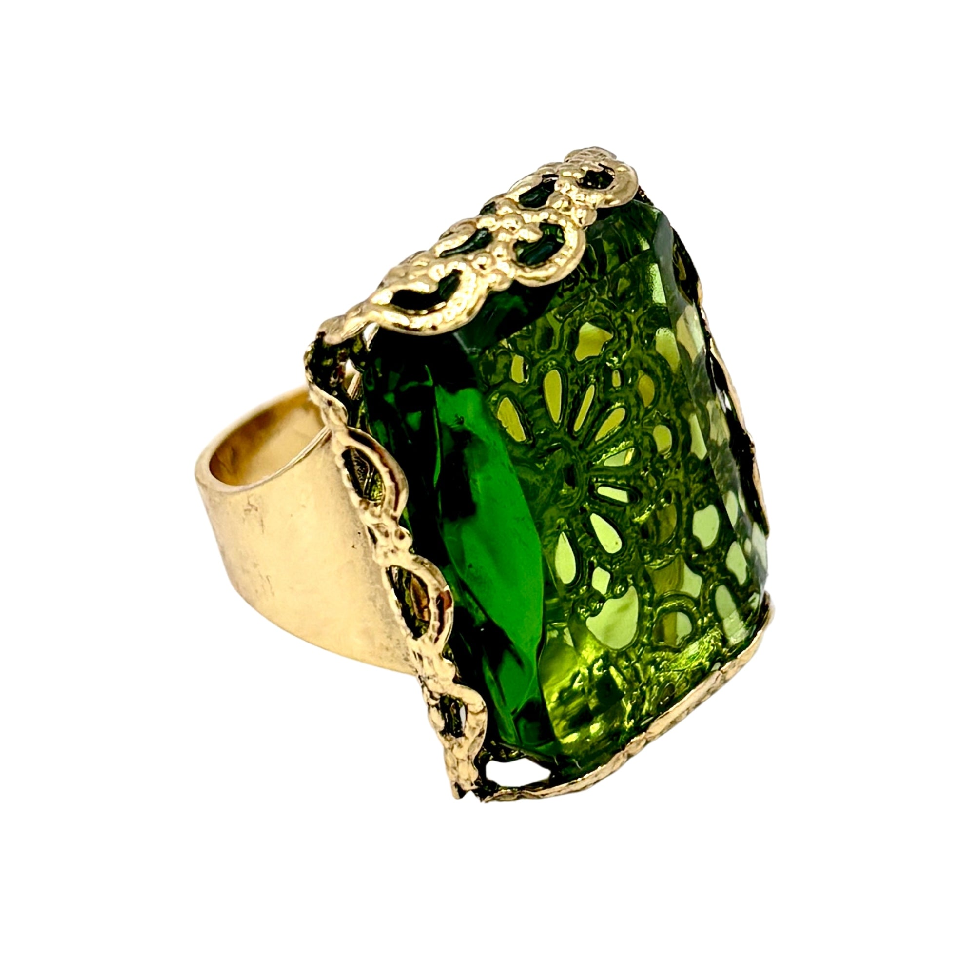 Bague artisanale en métal doré avec grand cristal vert facetté et monture ajourée aux détails travaillés