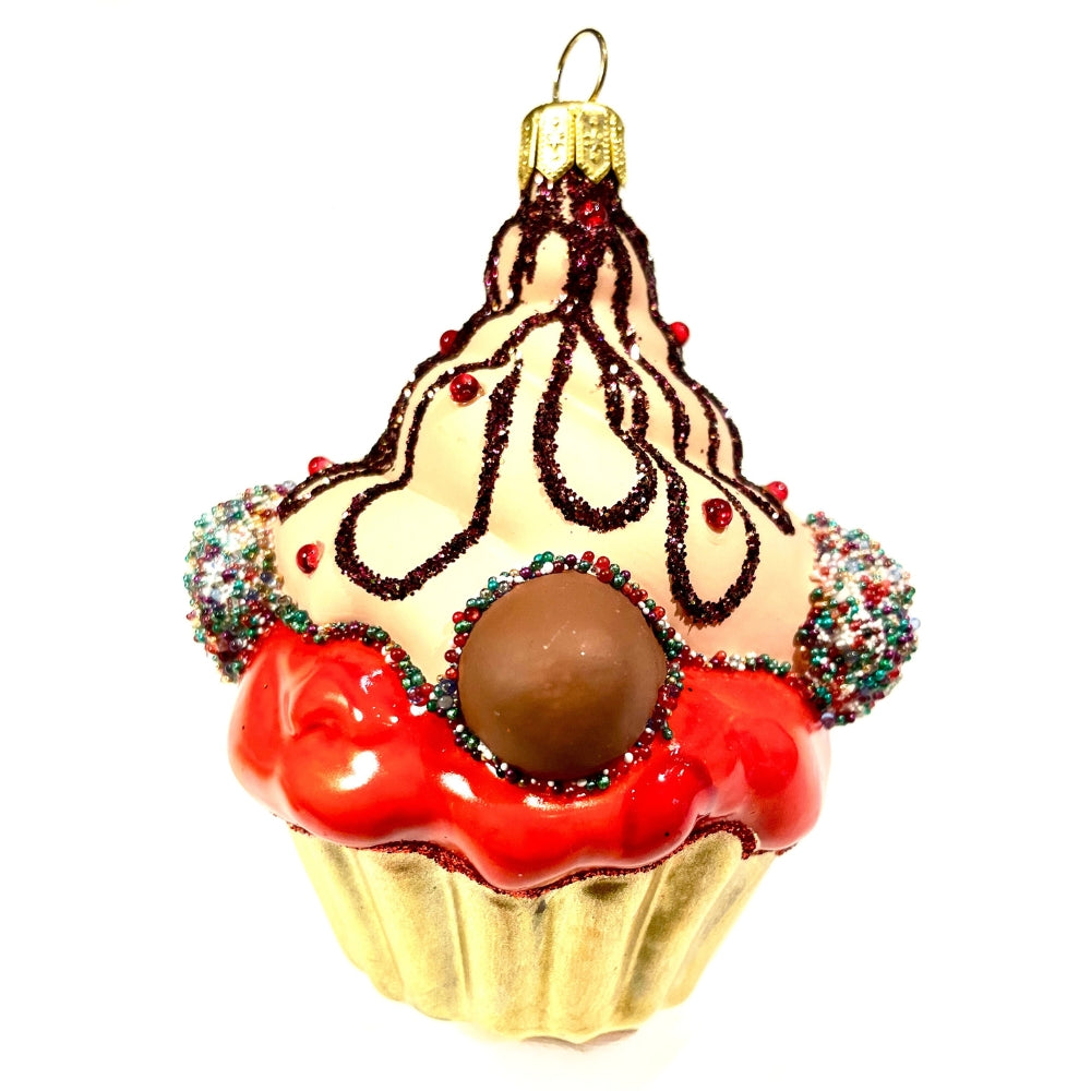 Gâteau en verre soufflé décoré de glaçage rouge, crème et perles multicolores