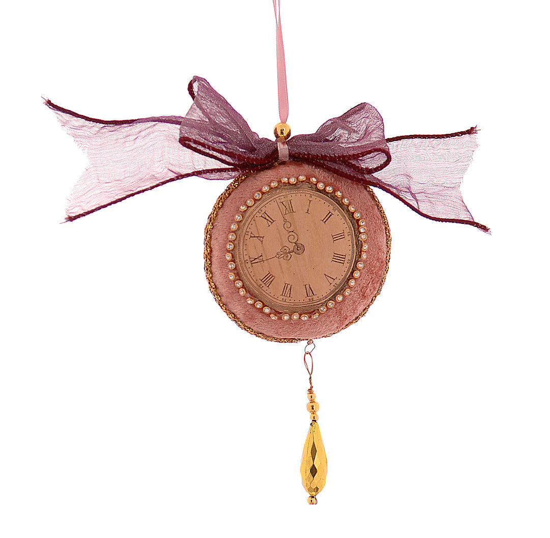 Horloge décorative en velours mauve en forme de boule de Noël, cadran à chiffres romains, noeud textile et détail doré