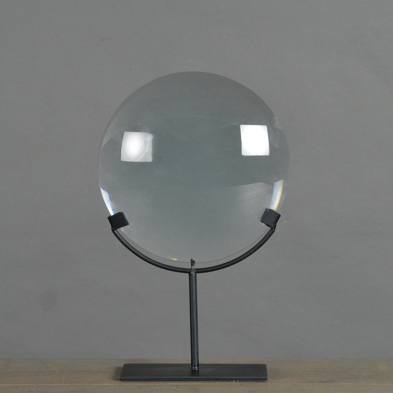 Loupe en verre sur socle en métal noir mat, vue de face