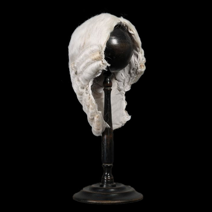 Perruque d'homme blanche en cheveux synthétiques, style juges anglais sur support noir