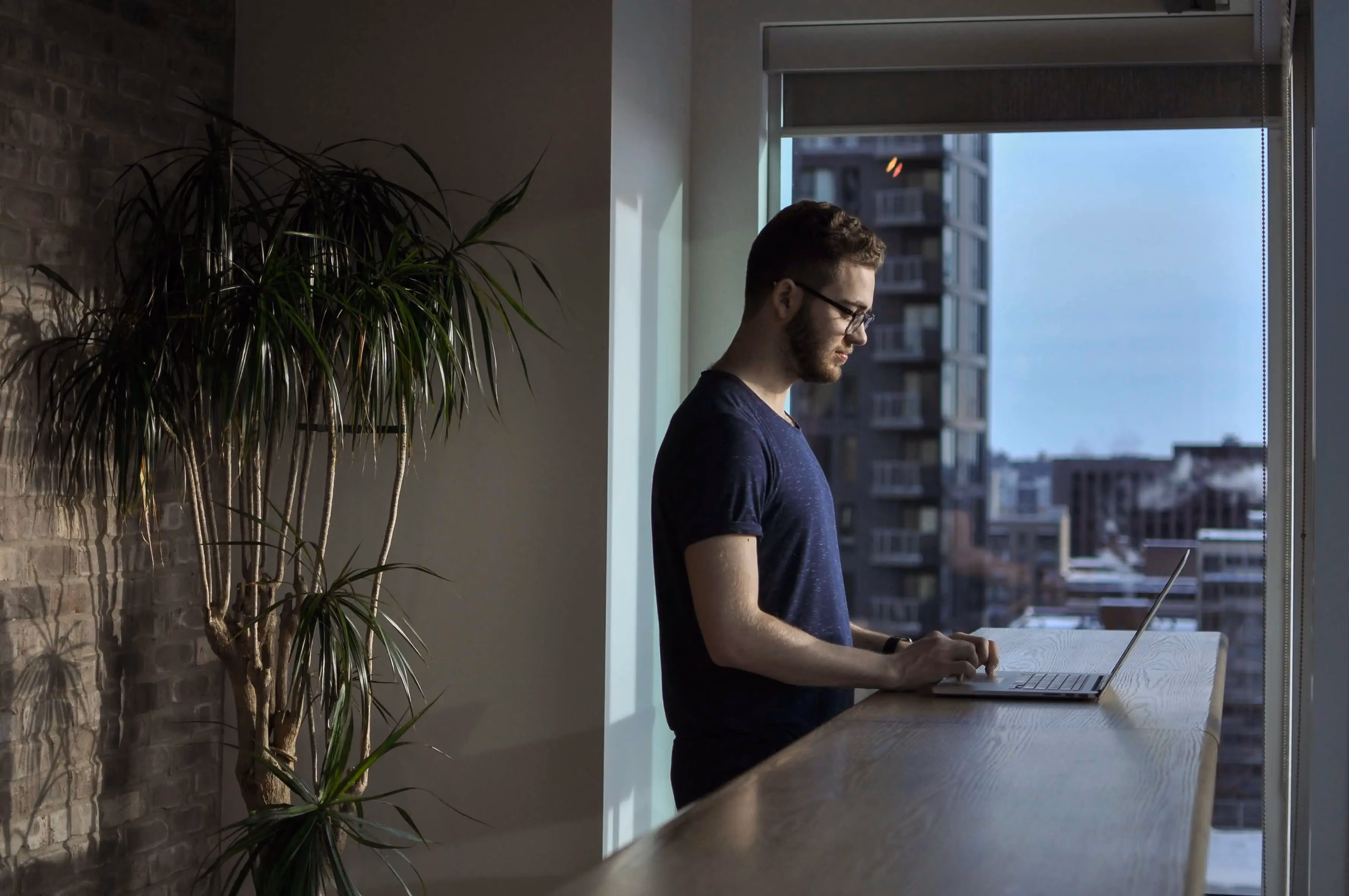 A man sitting at a table using a laptop computer