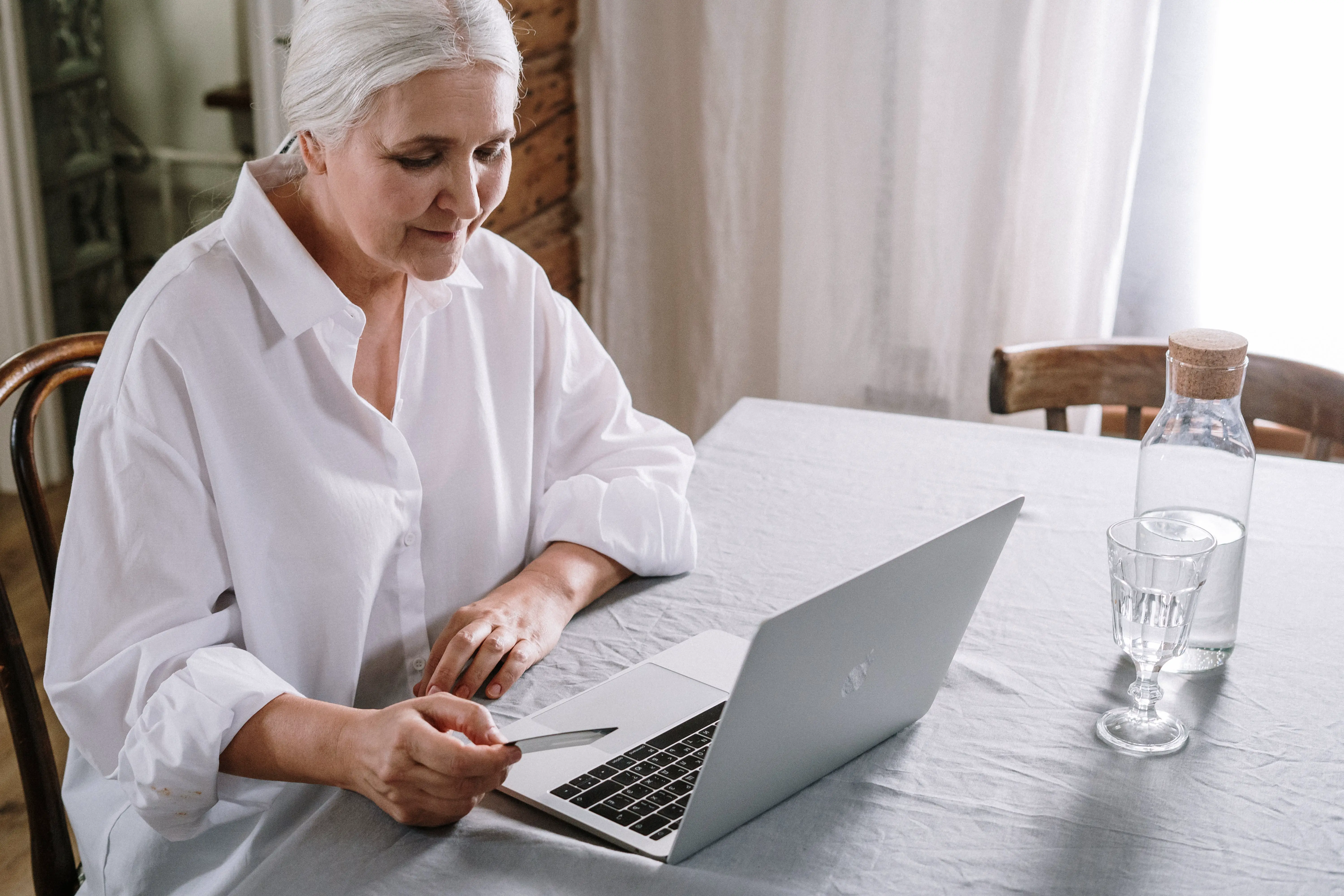 A woman sitting at a table using a laptop computer