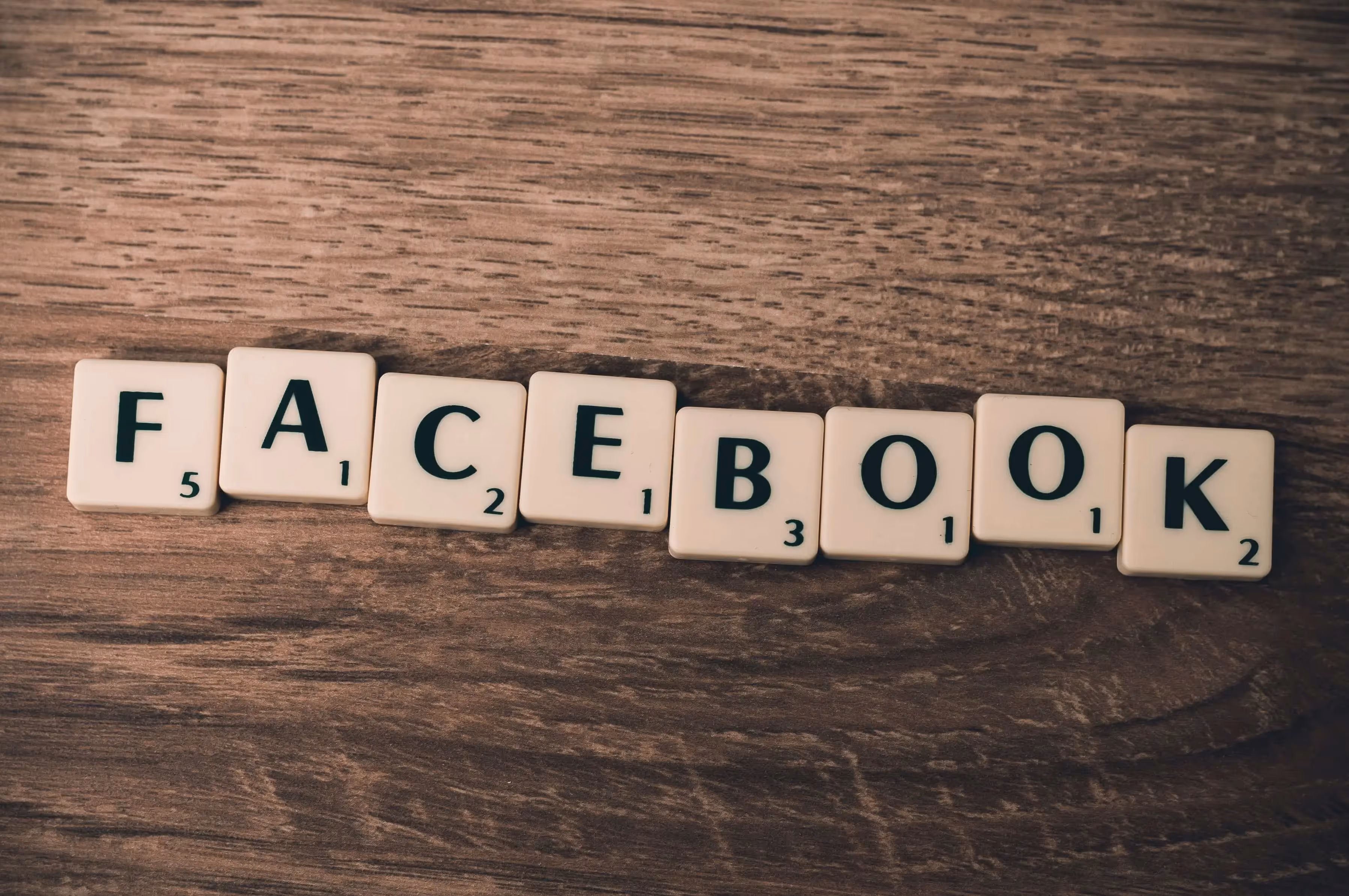 The word facebook spelled with scrabble blocks on a wooden table