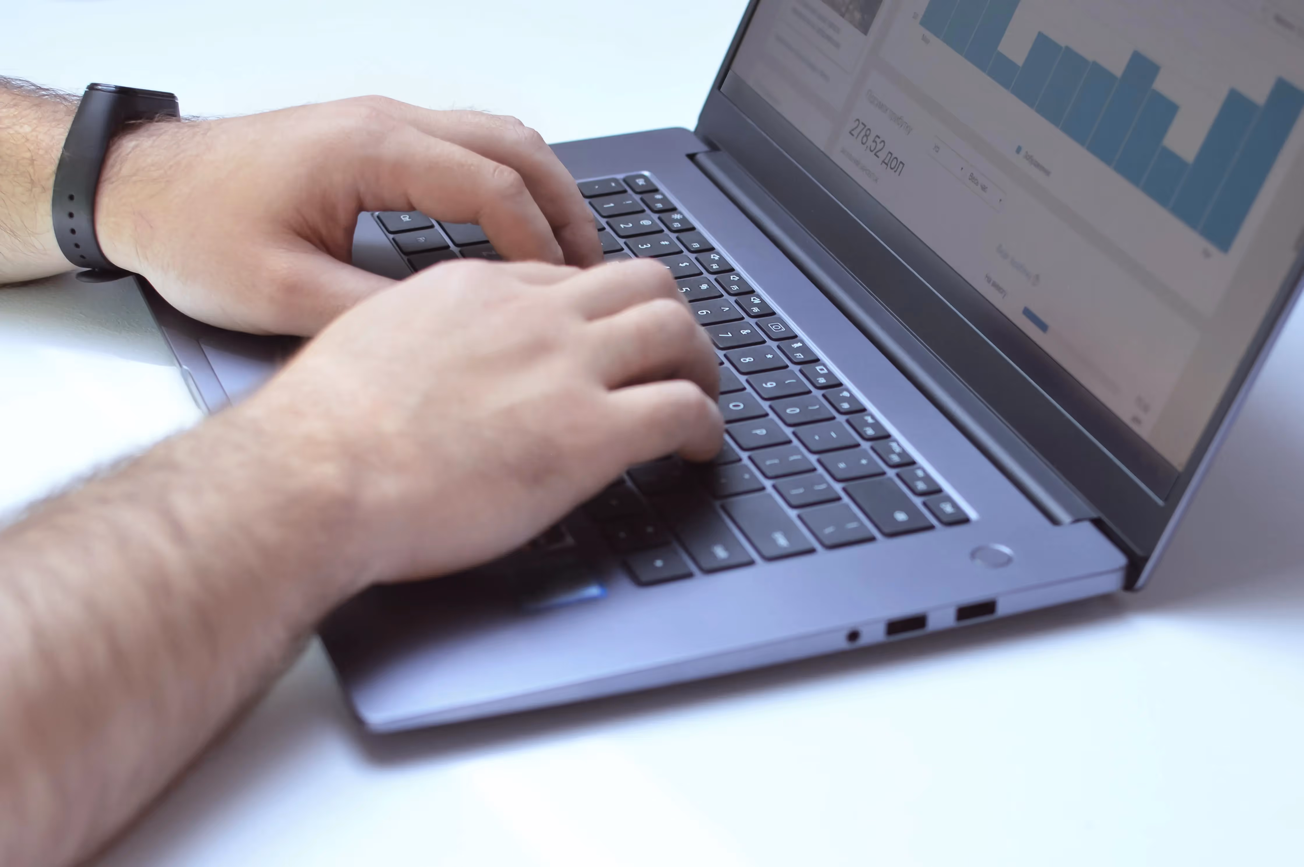 A man is typing on a laptop computer