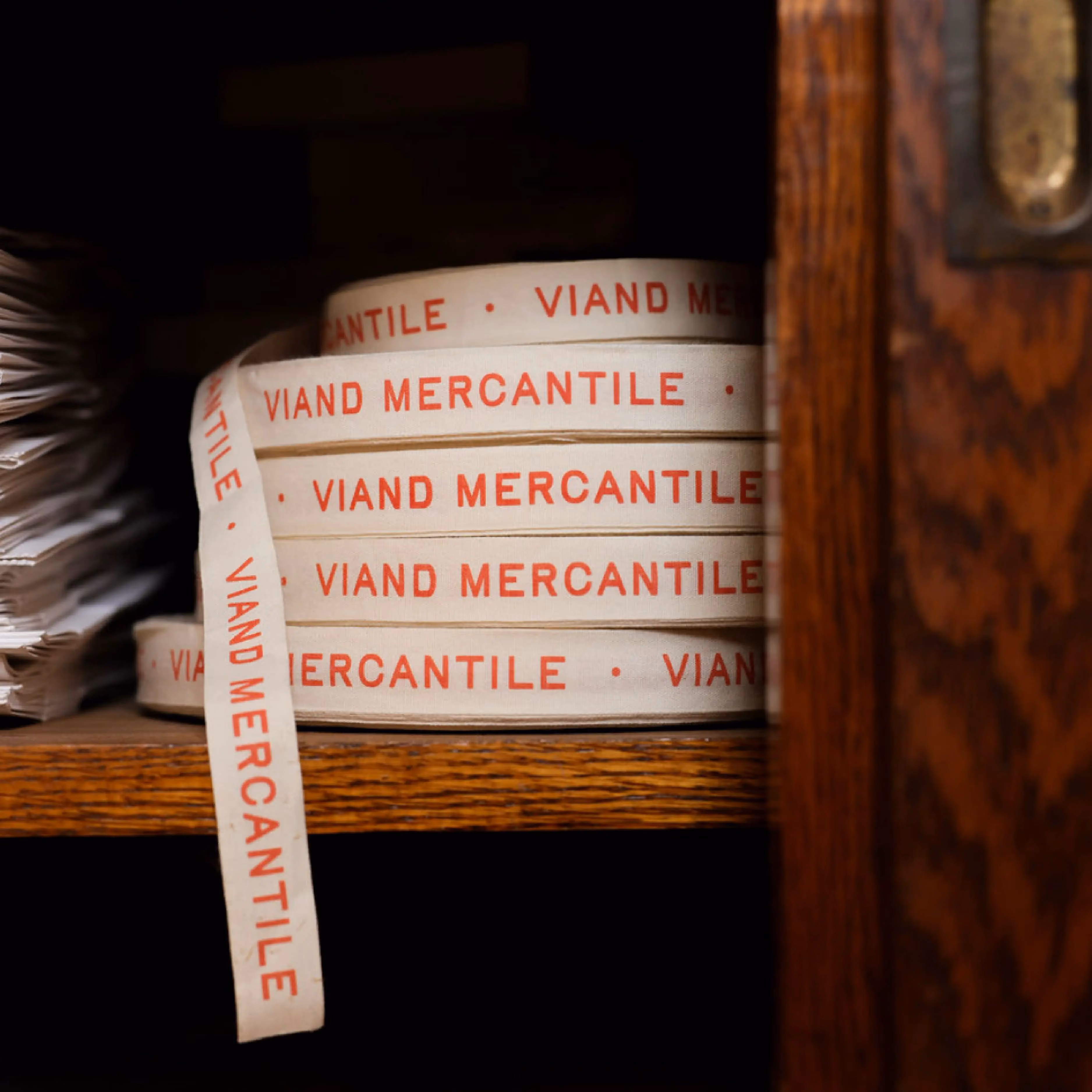 Stacked vintage "Viand Mercantile" labels on wooden shelf