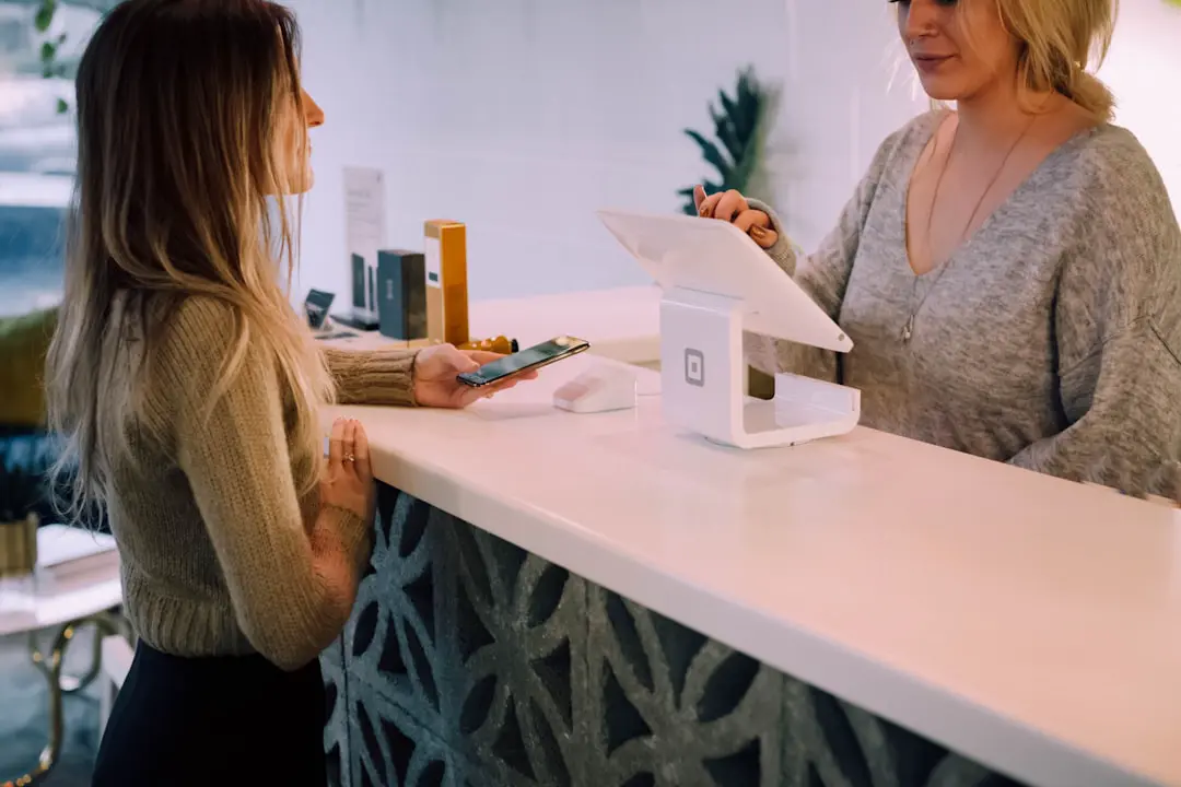 Two women standing at a counter with a tablet