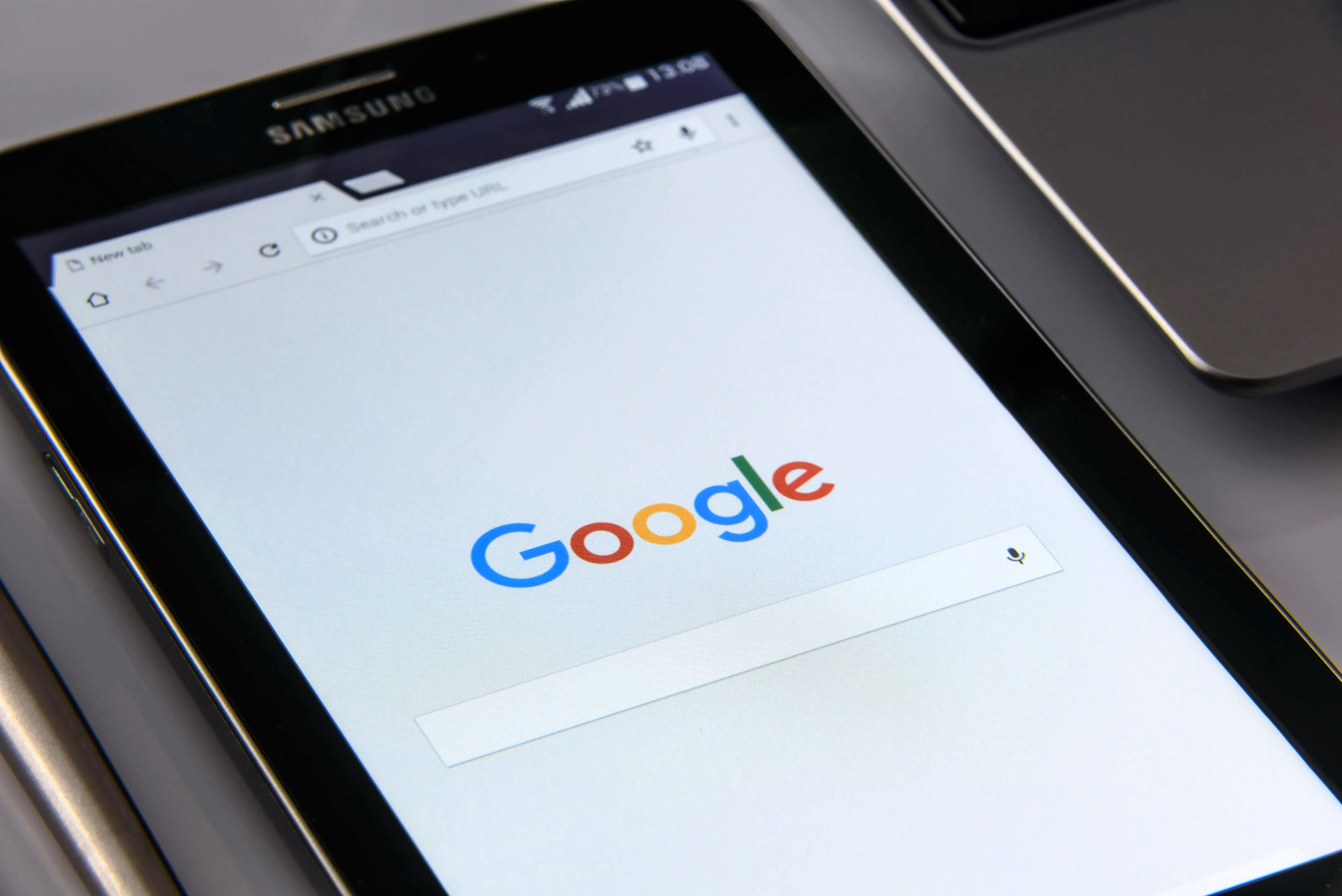 A close up of a cell phone with the google logo on it