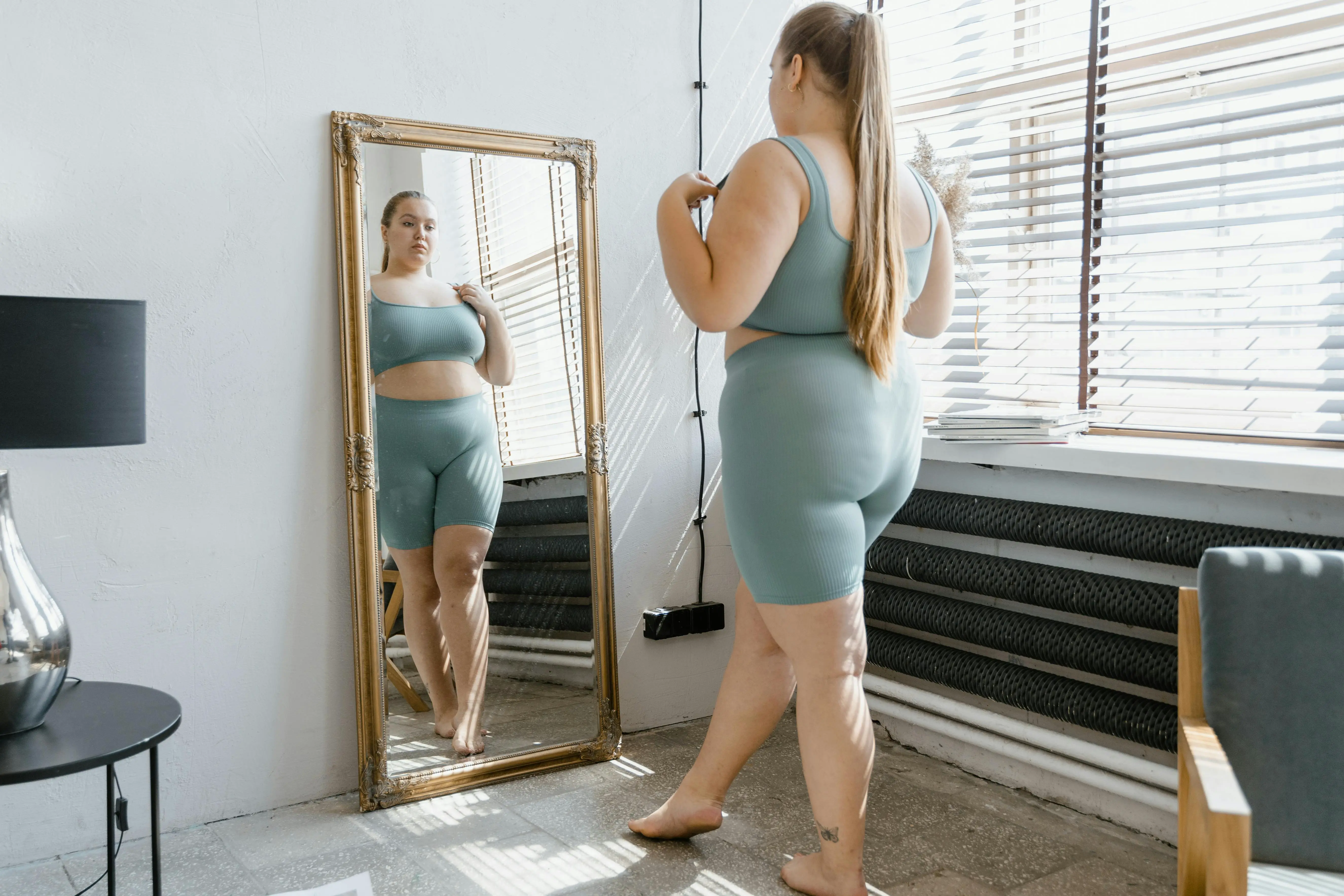 A woman standing in front of a mirror brushing her teeth