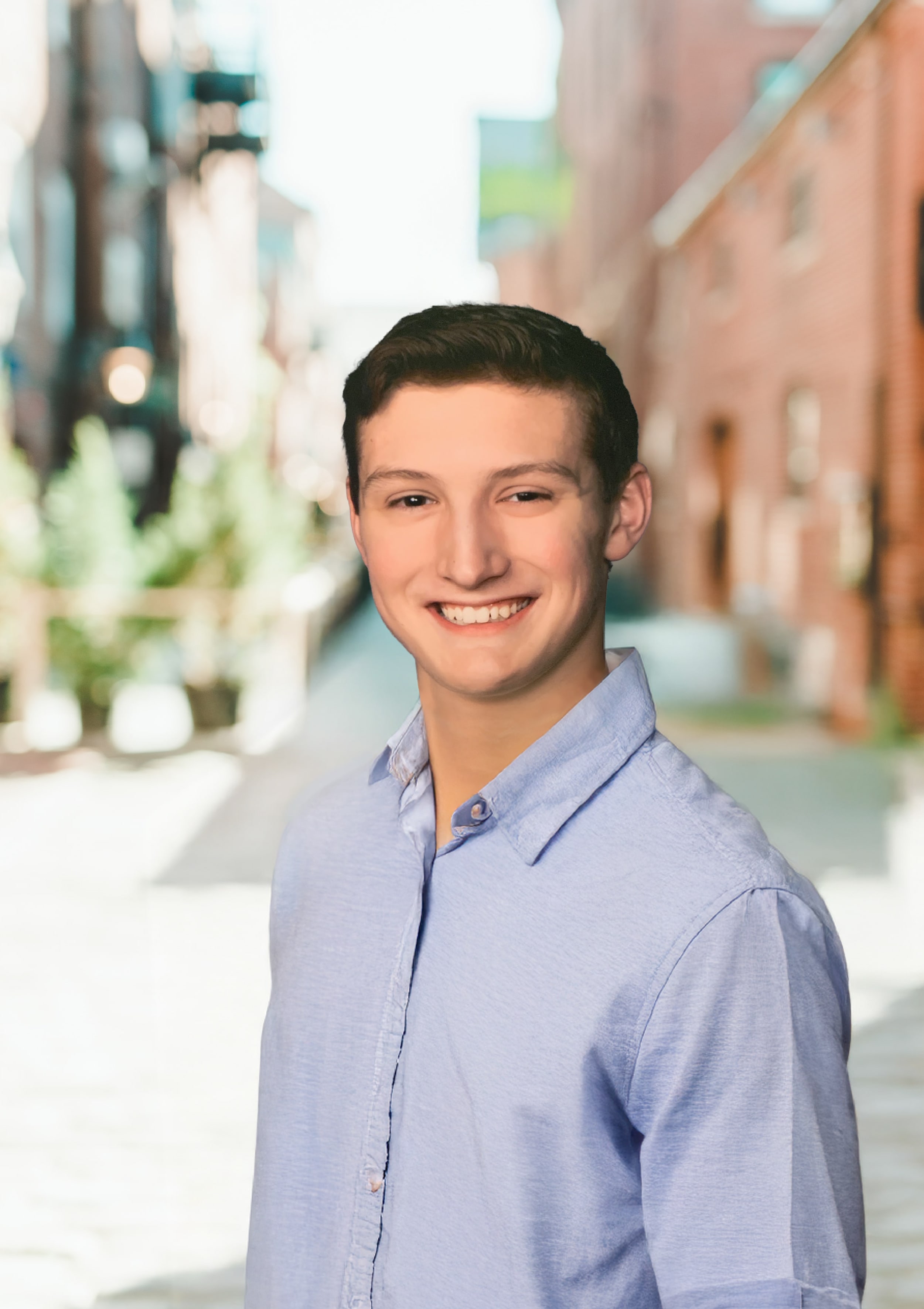 A man standing in front of background buildings