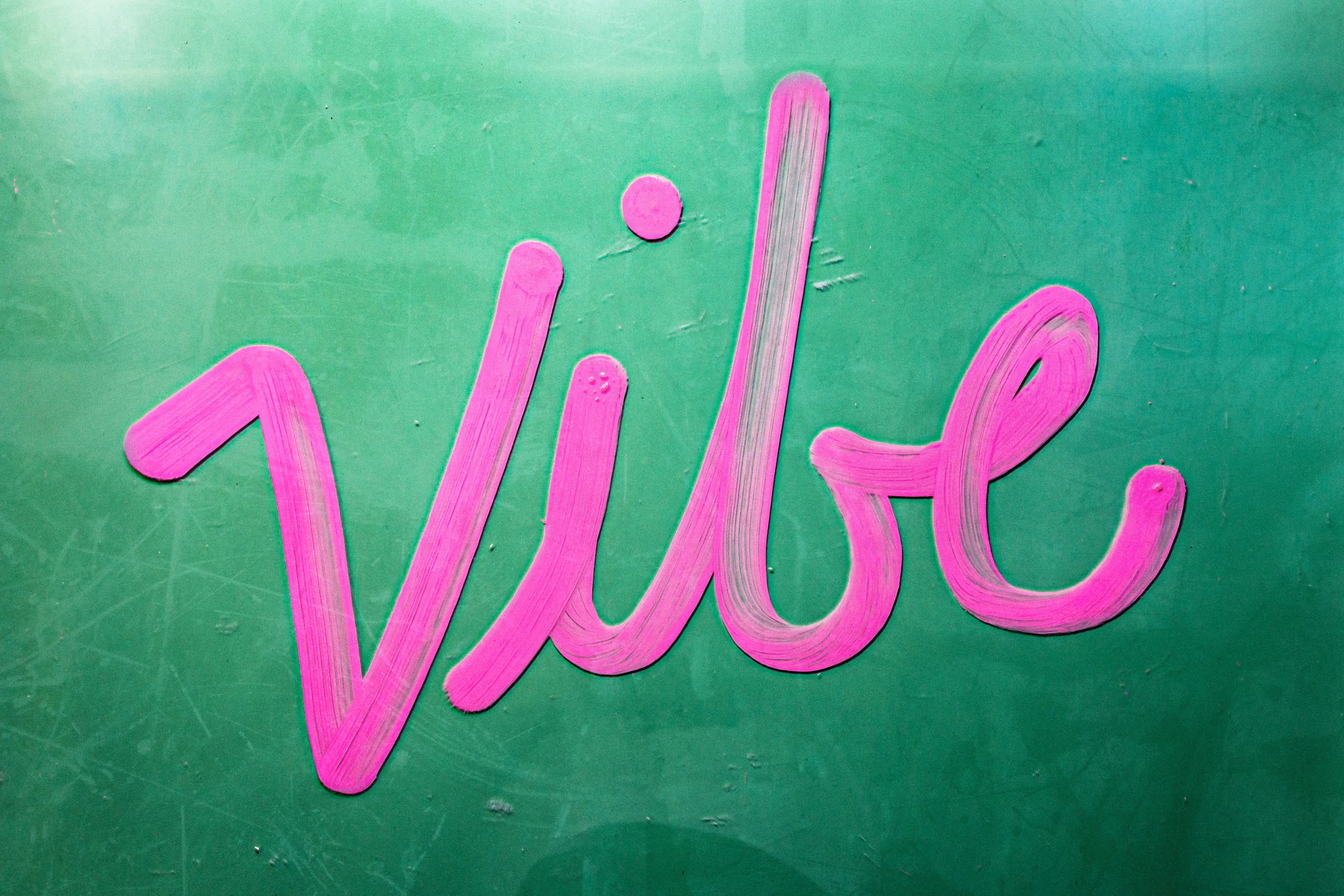A green sign with pink writing that says vile