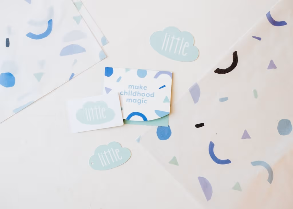 Little children's boutique collateral design with cloud-shaped branding on a soft blue background