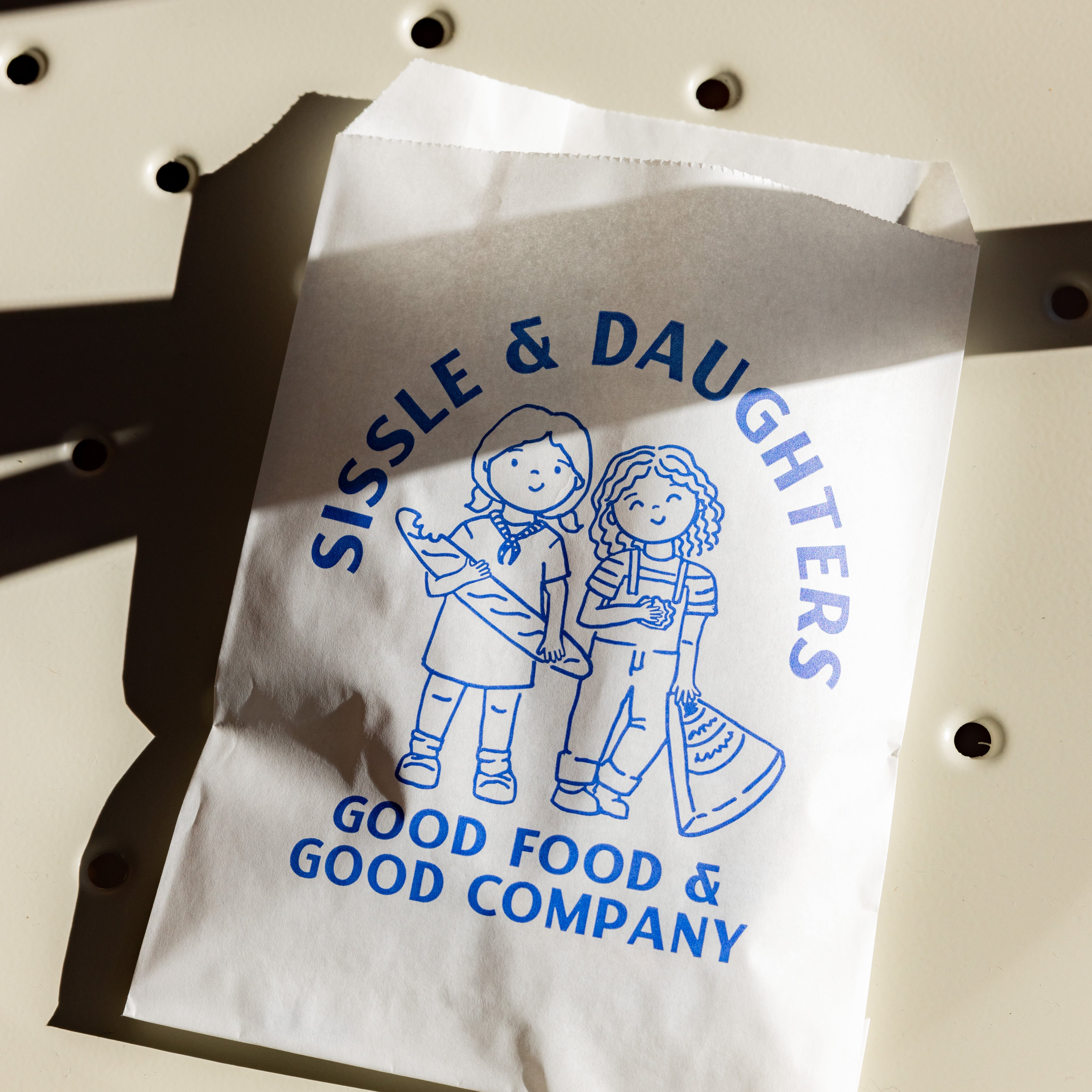 Sissle & Daughters in-store signage and collateral featuring the custom doodle pattern