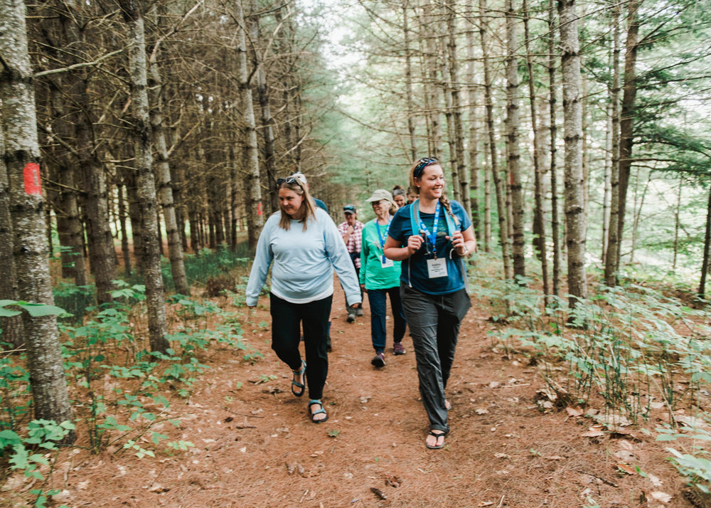 A group of Ecology School program participants hiking a wooded trail at River Bend Farm in Saco, Maine