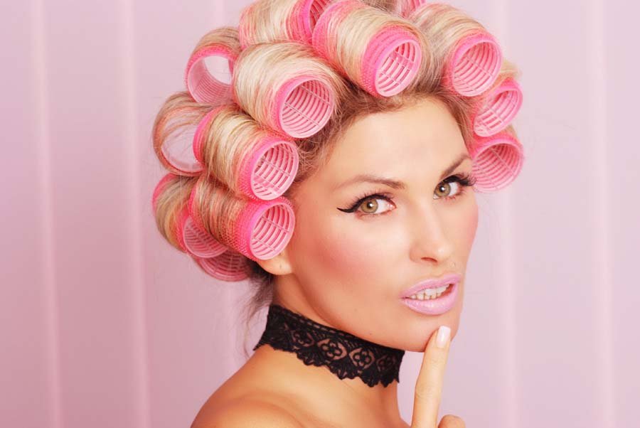 model mit lockenwickler nach einer makeup behandlung