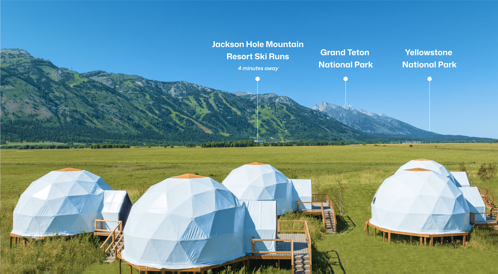 Geodesic dome in front of stream and Teton Mountains with pins pointing out JHMR, Grand Teton National Park, and Yellow Stone National Park.
