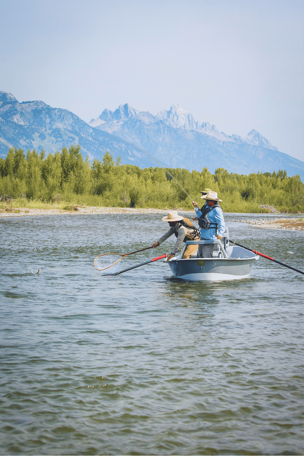 Man standing in river casting fishing rod