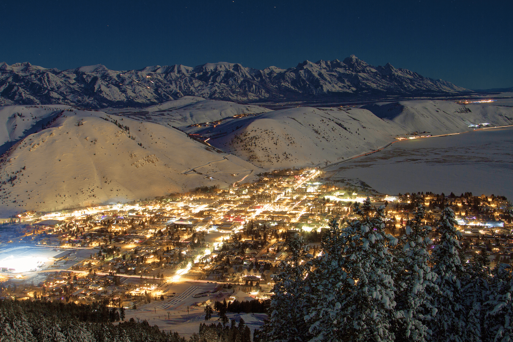 Geodesic dome in front of stream and Teton Mountains with pins pointing out JHMR, Grand Teton National Park, and Yellow Stone National Park.