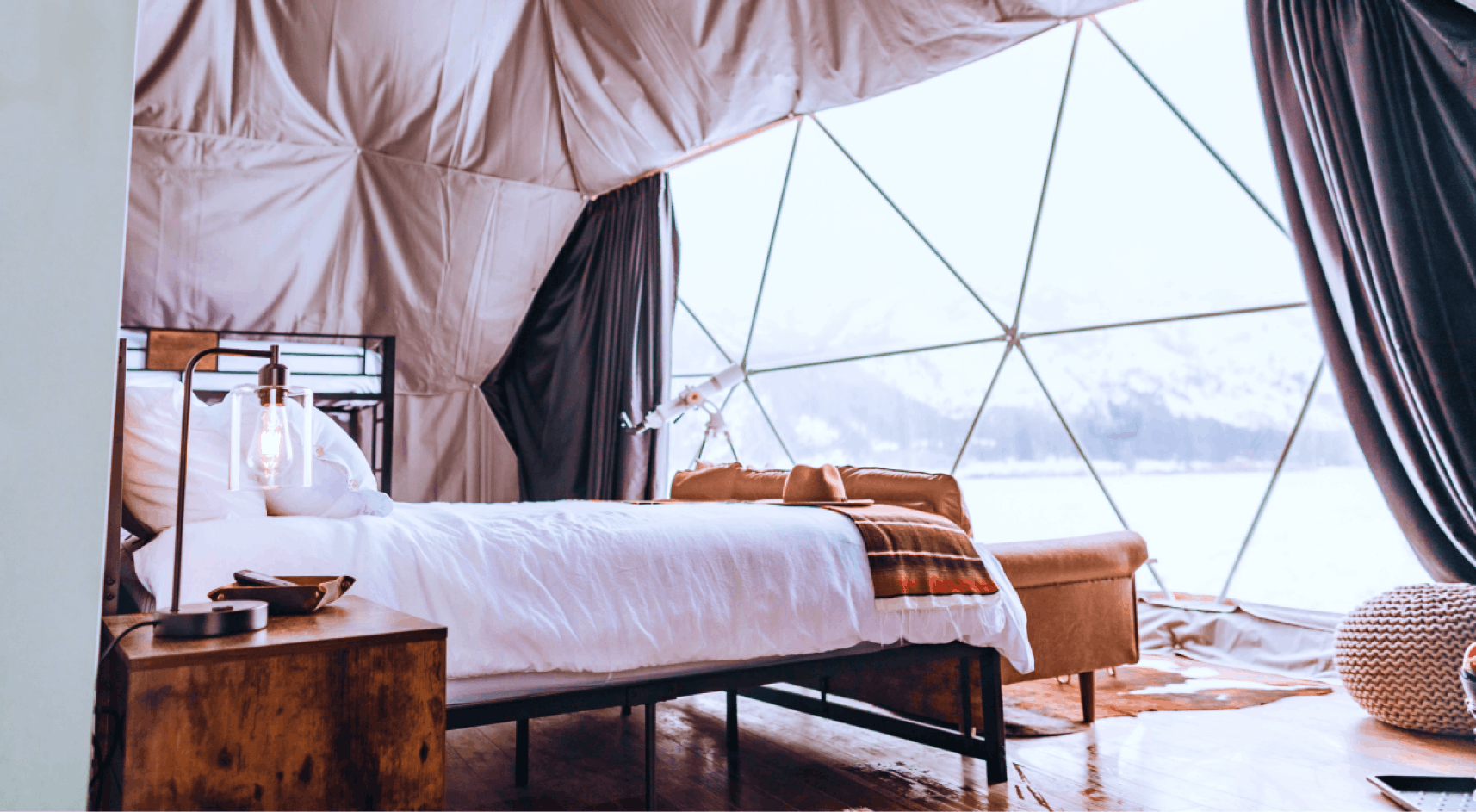 Geodesic dome in front of stream and Teton Mountains.