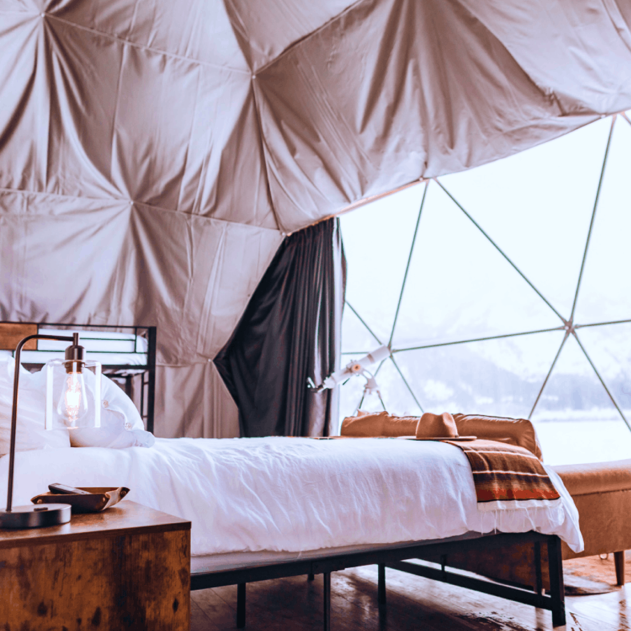 Geodesic dome in front of stream and Teton Mountains.
