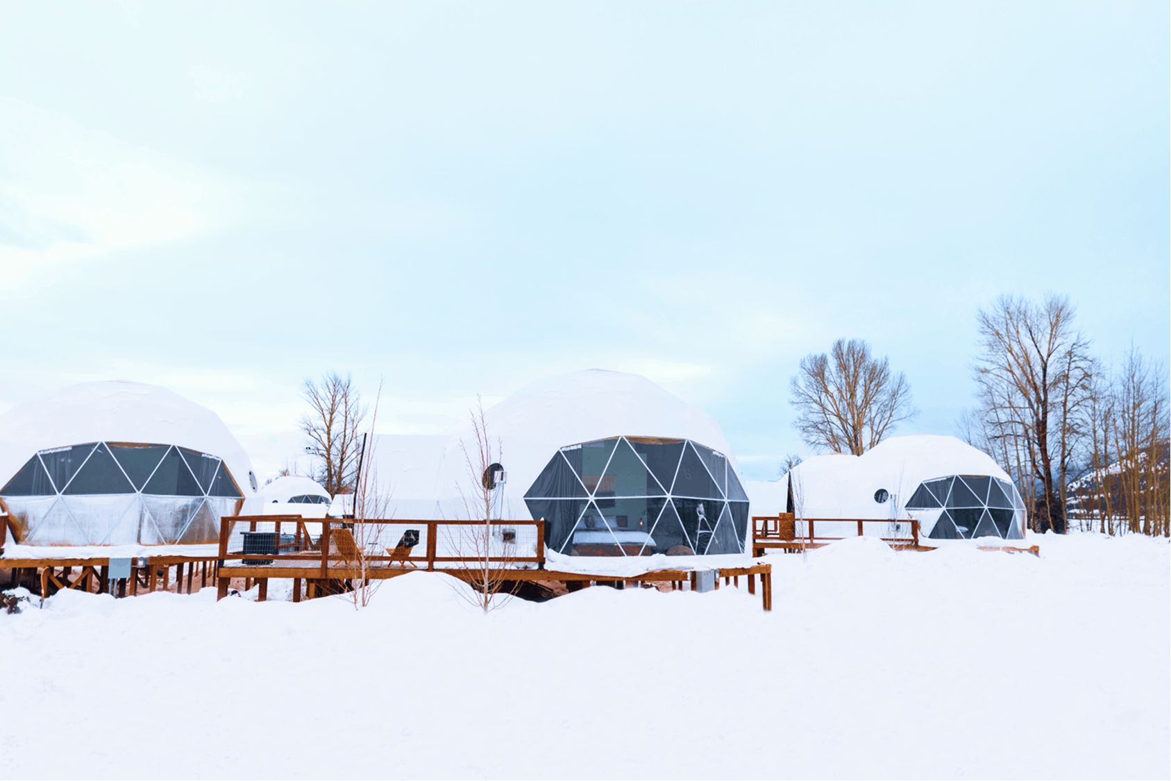 Geodesic dome in front of stream and Teton Mountains.