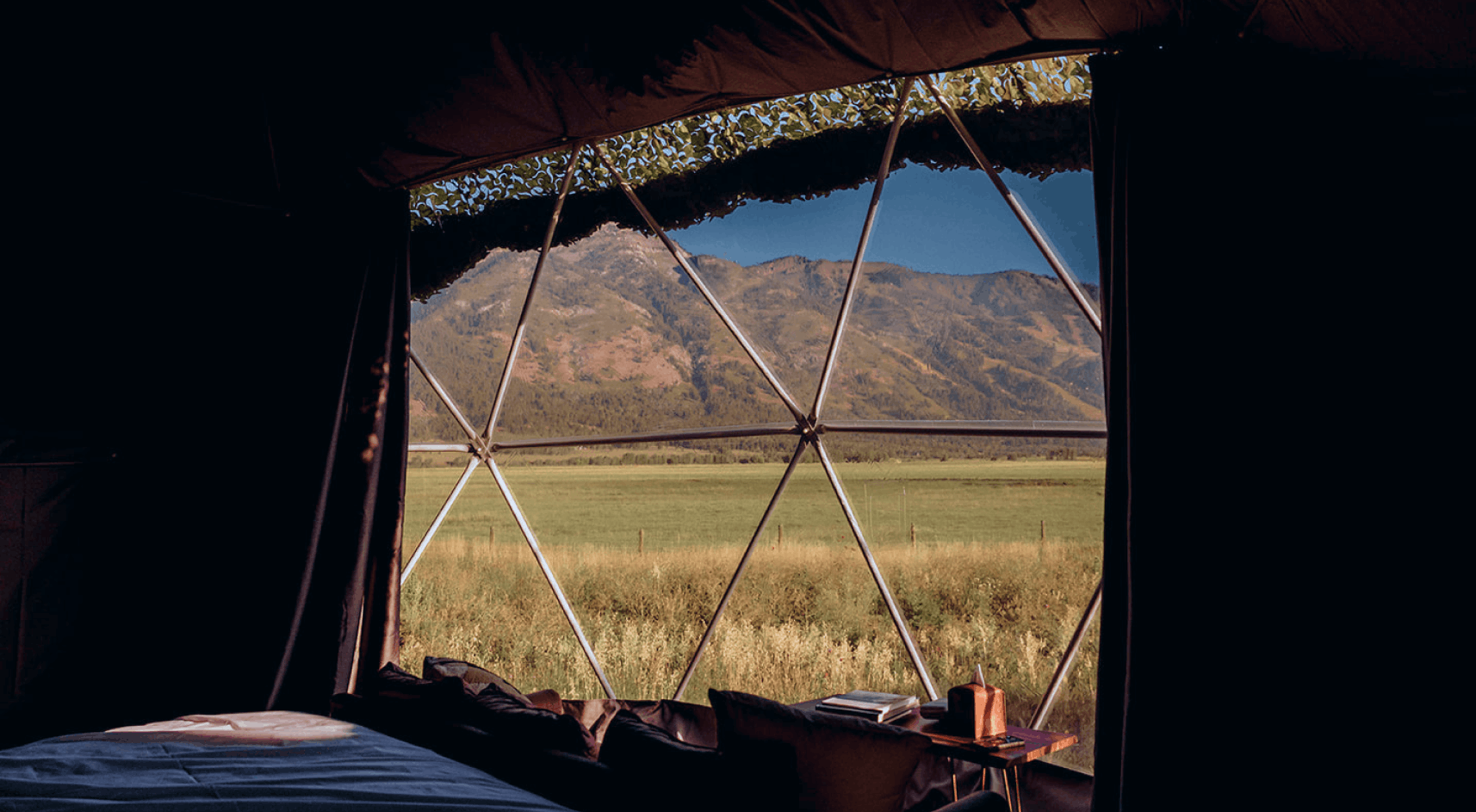 View of geodesic domes and staff building in front of Teton Mountains.