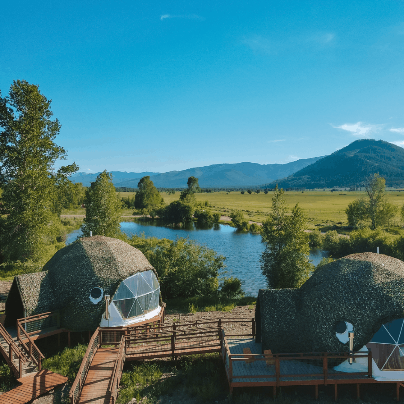 Geodesic dome in front of stream and Teton Mountains.