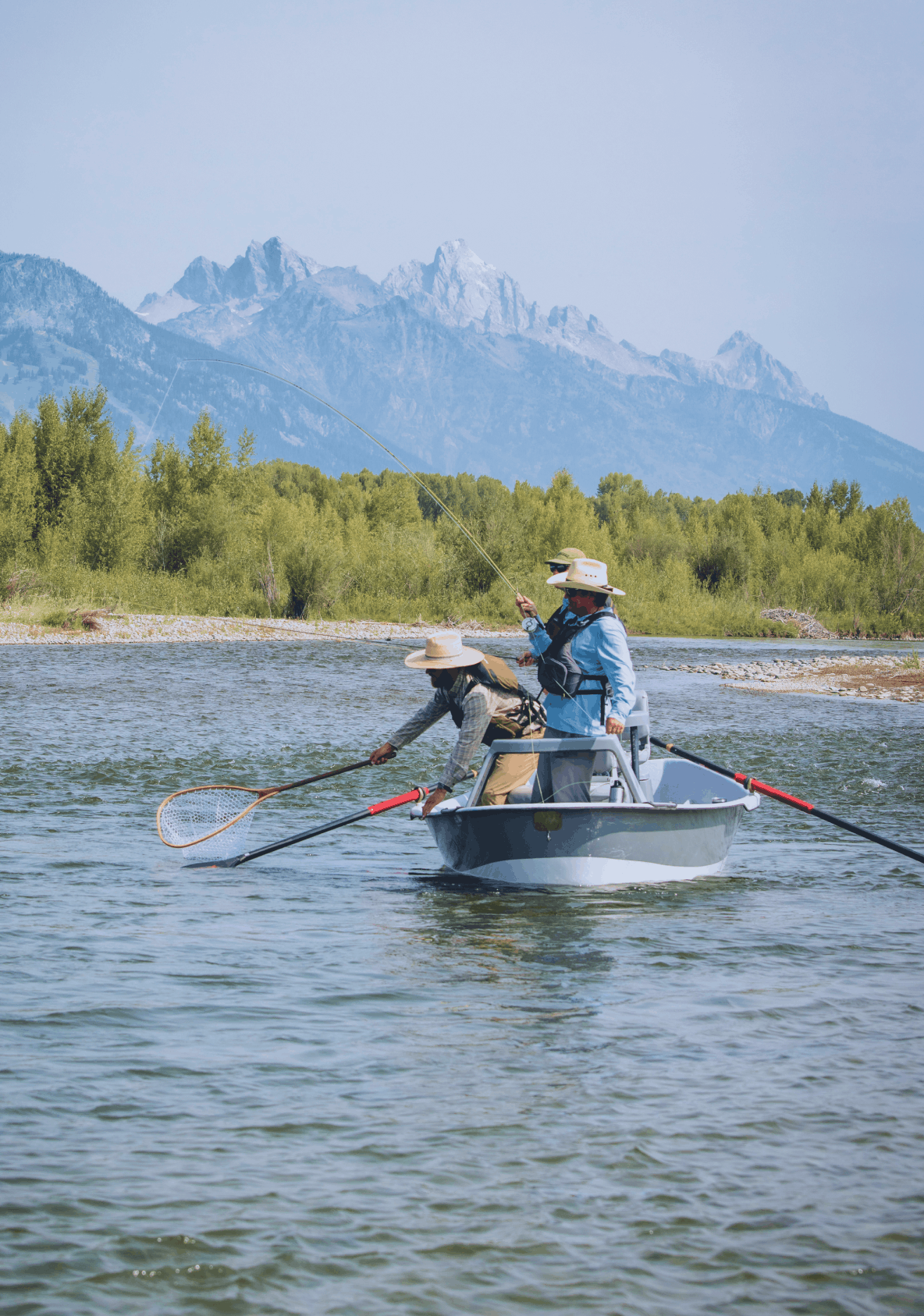 Man standing in river casting fishing rod