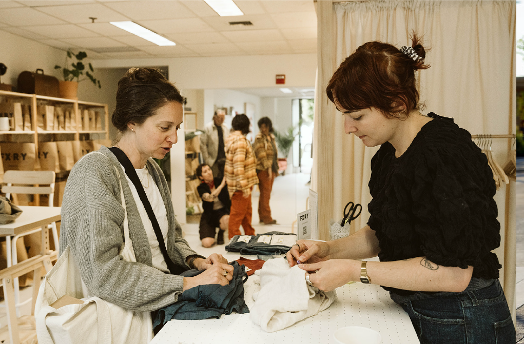 An FXRY fixer working with a customer at the studio counter