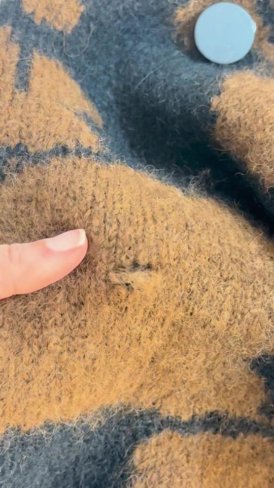A small hole in the tan motif of a jacquard cardigan