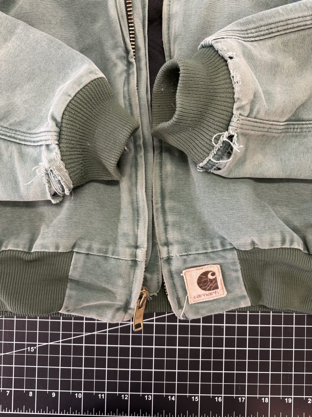 A canvas work jacket with both cuffs worn through
