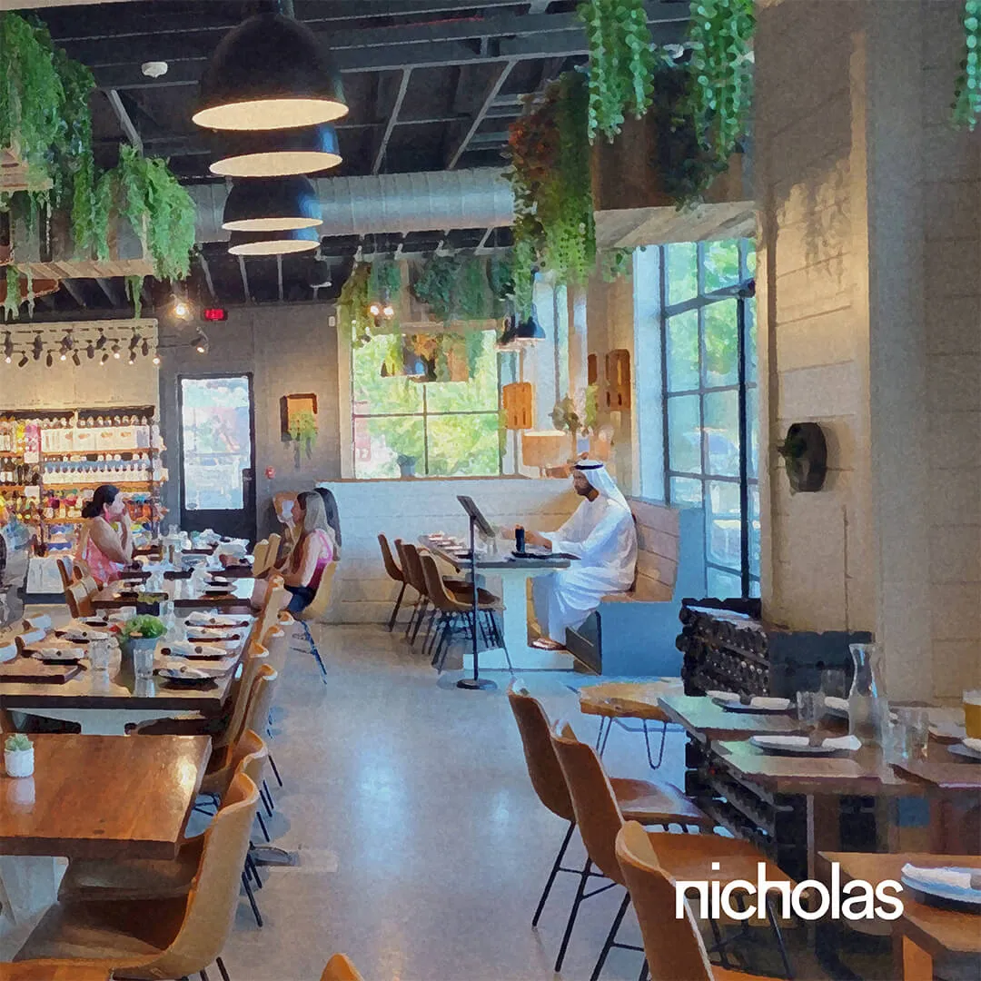 Modern café with wood design and greenery, where people meet and work, illustrating how hospitality design connects people