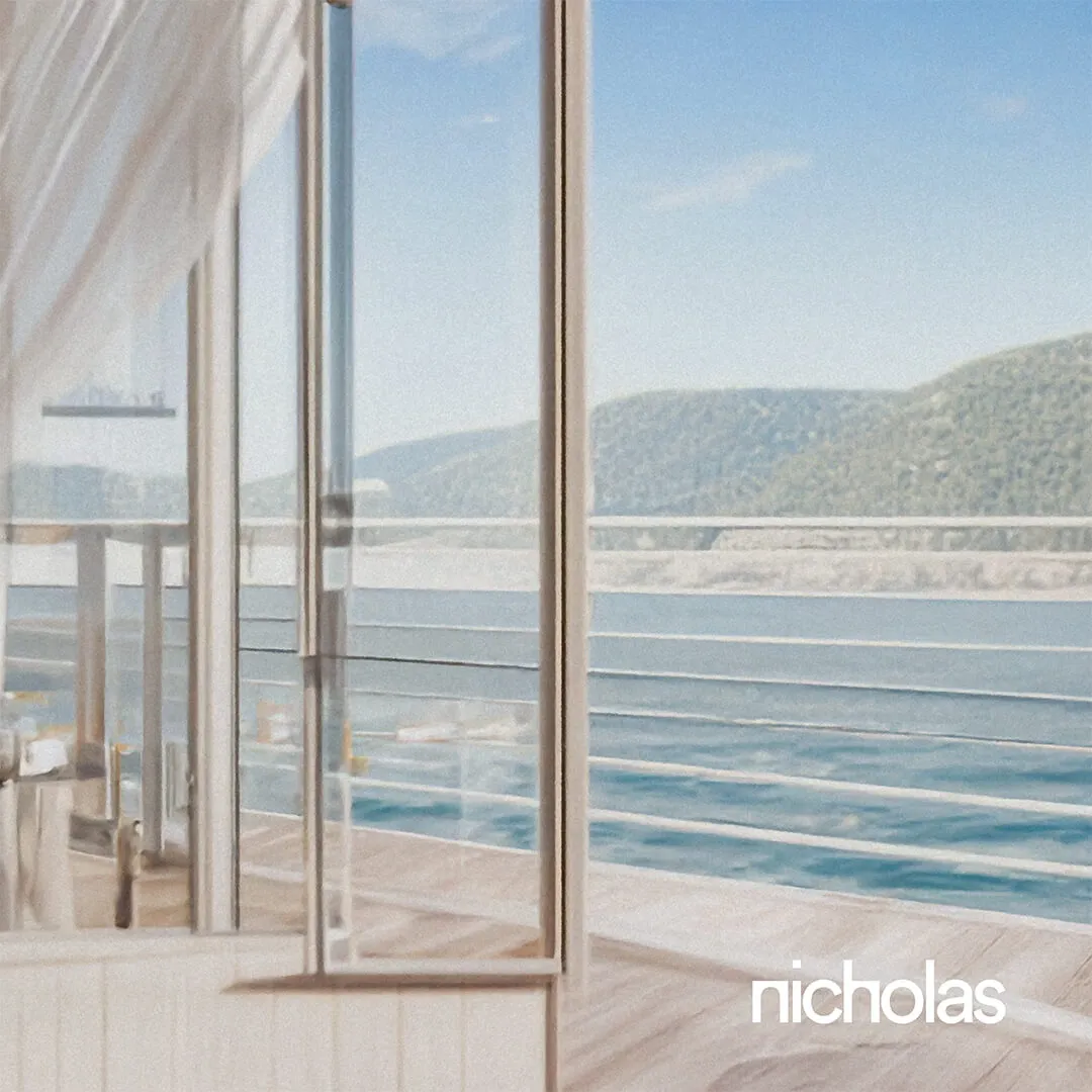 Bright hotel room with sea-facing glass wall, embodying personalized and elevated hospitality design