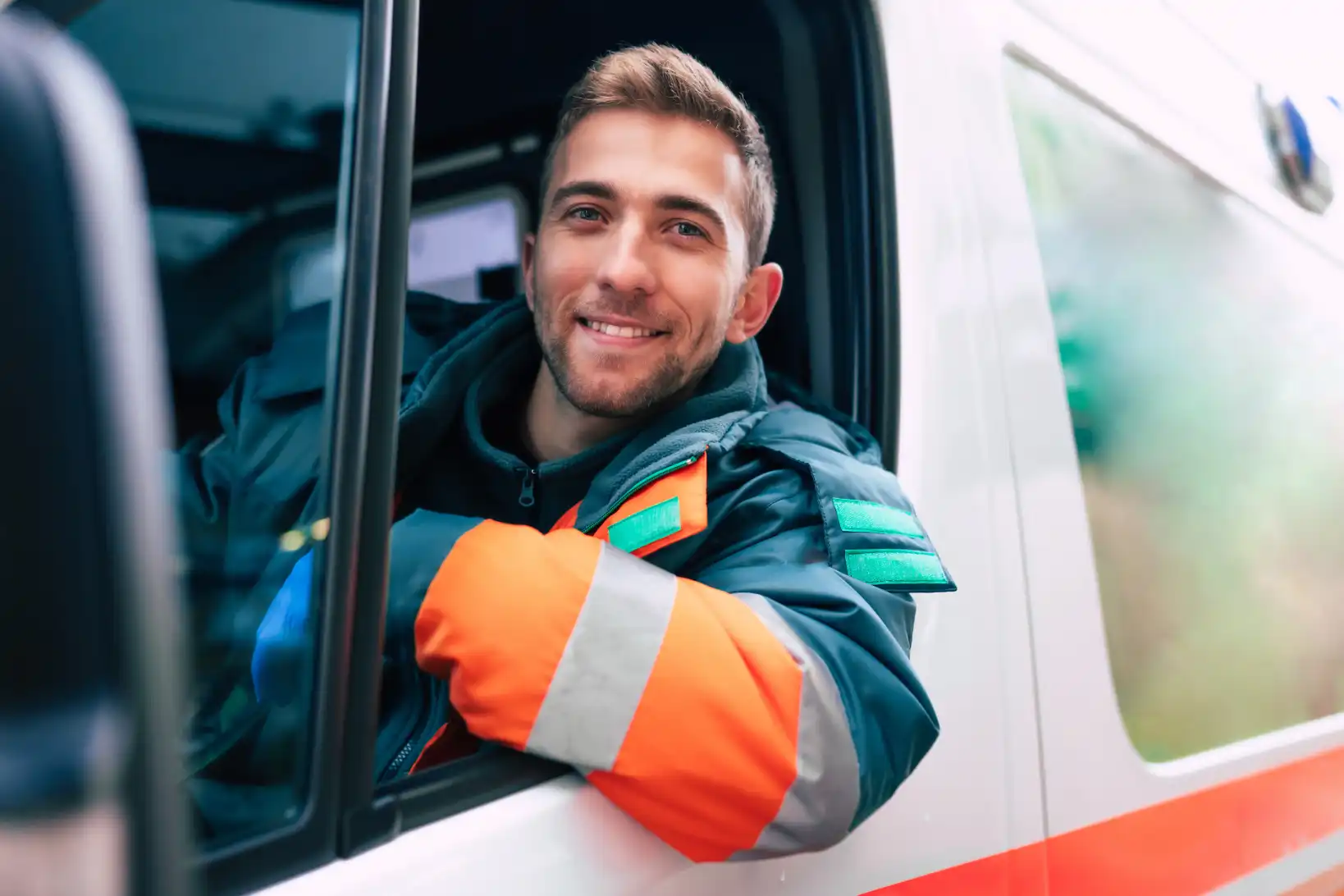 Handsome male paramedic with short brown hair driving ambulance and hoping to being a Physician Assistant bridge