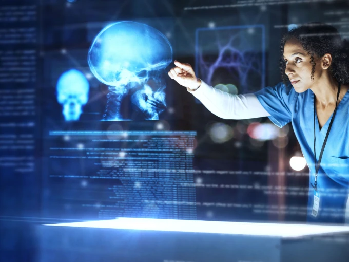 Nurse using artificial intelligence technology to analyze a patient’s brain scan on a digital screen.