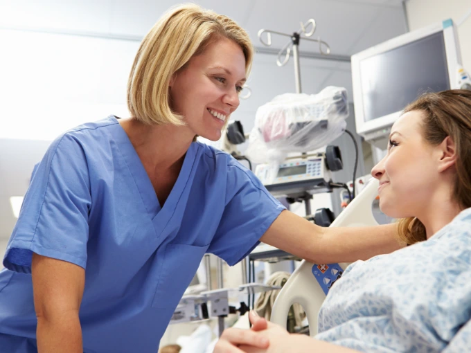 Blonde woman in blue scrubs building patient trust in nursing