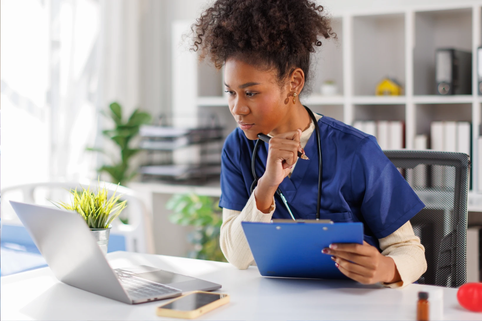 LPN studying online RN nursing program on laptop while reviewing clinical notes for LPN to RN bridge program 2026