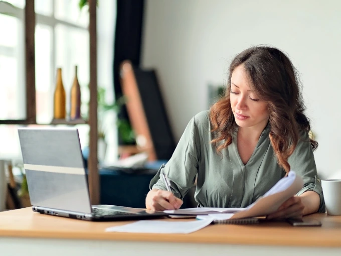 Woman on laptop checking to see if she is on a nursing school waitlist