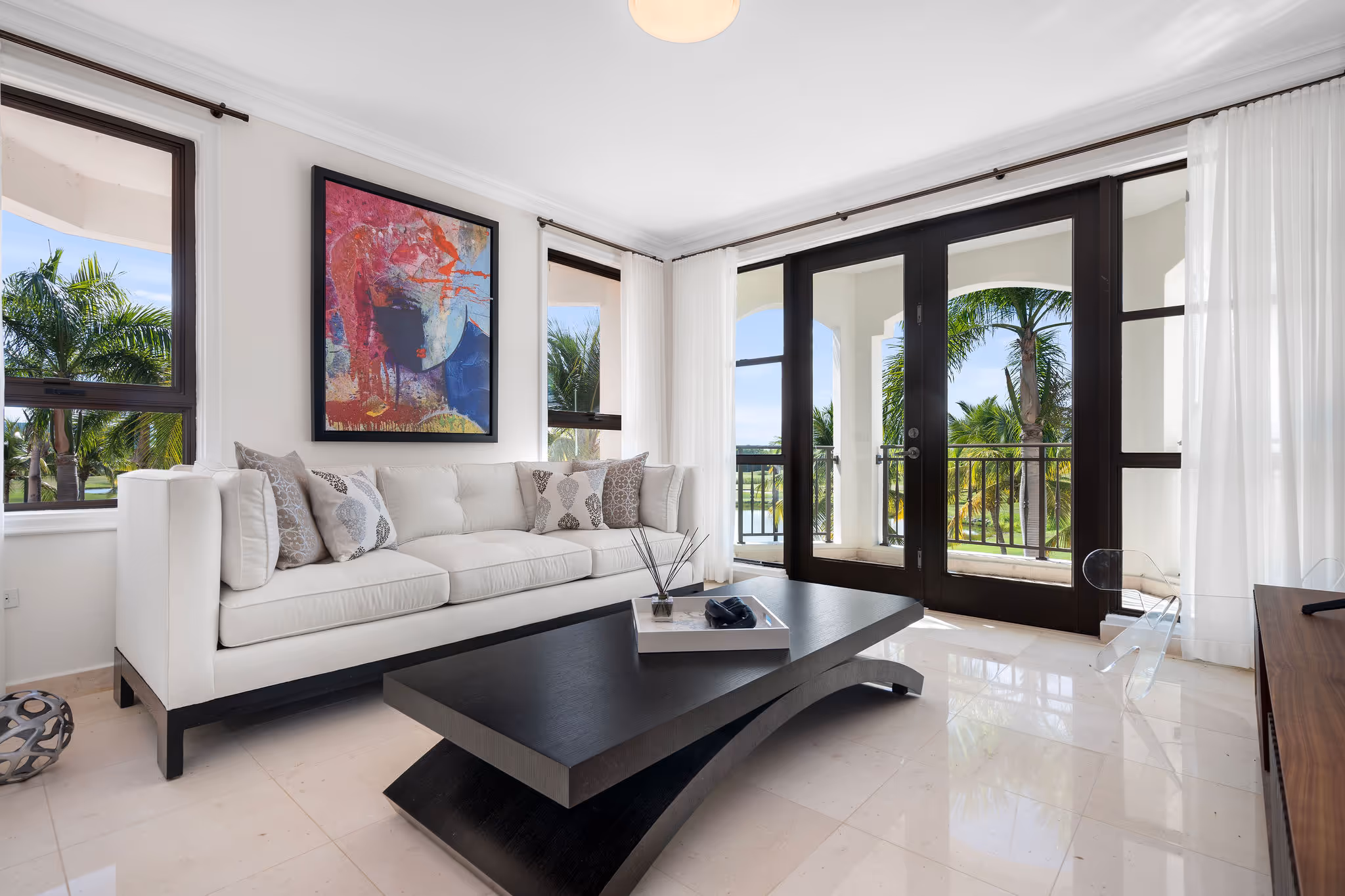 13. Country Club Villas F302 Image 14: Stylish second living room with floor-to-ceiling windows, contemporary furniture, and direct access to a private balcony with breathtaking tropical views.