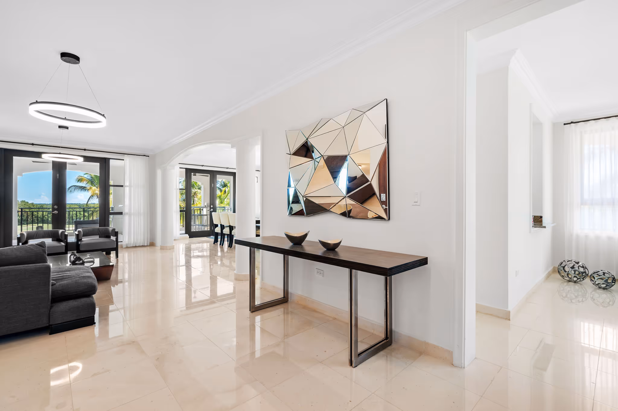 3. Country Club Villas F302 Image 3: Welcoming entrance view of the spacious open-concept living area with breathtaking golf course views in the backdrop.