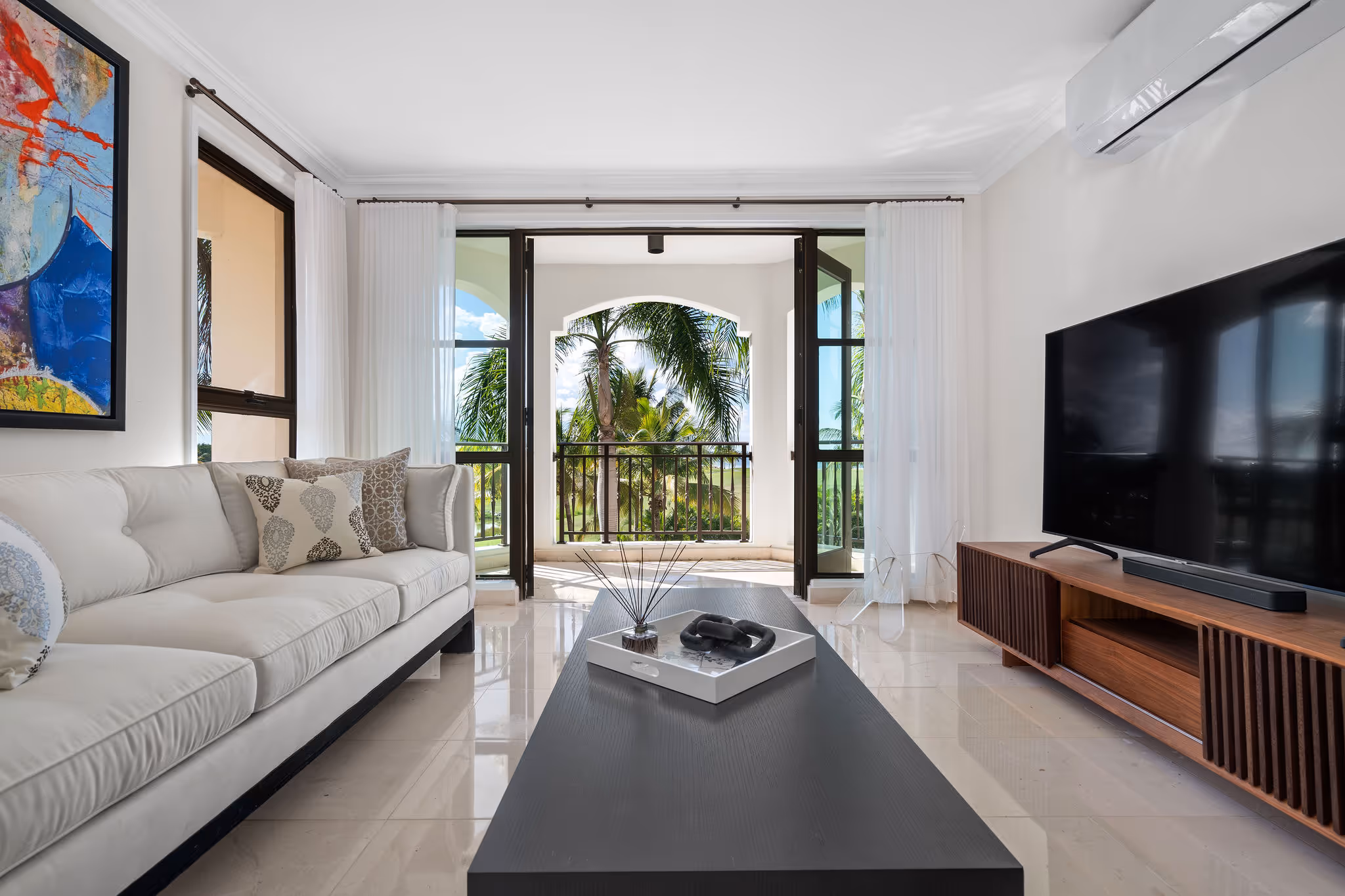 14. Country Club Villas F302 Image 8: Luxurious secondary living space with direct access to private balcony and stunning golf course backdrop.