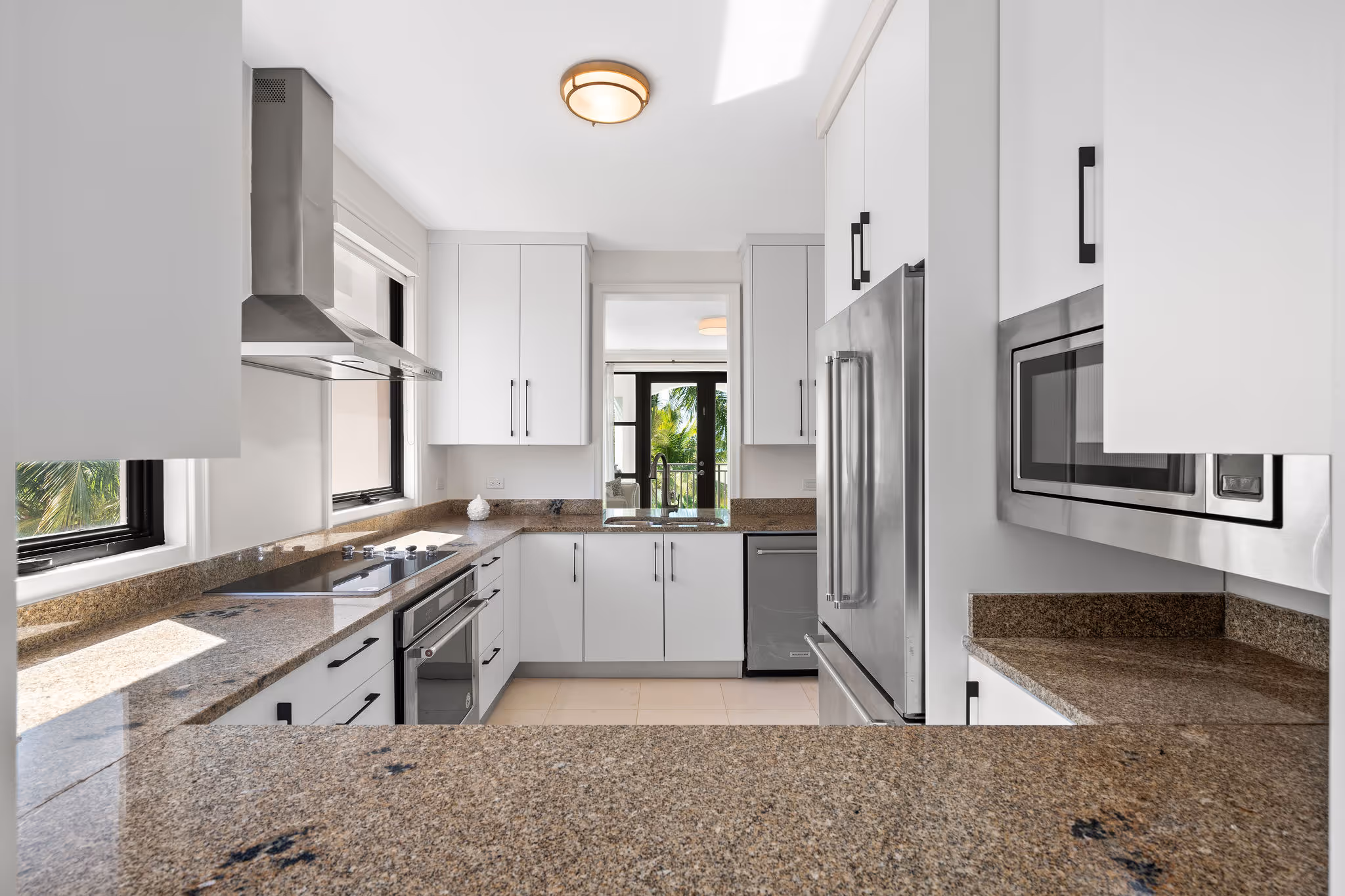10. Country Club Villas F302 Image 6: Fully equipped kitchen with granite countertops, stainless steel appliances, and custom cabinetry.