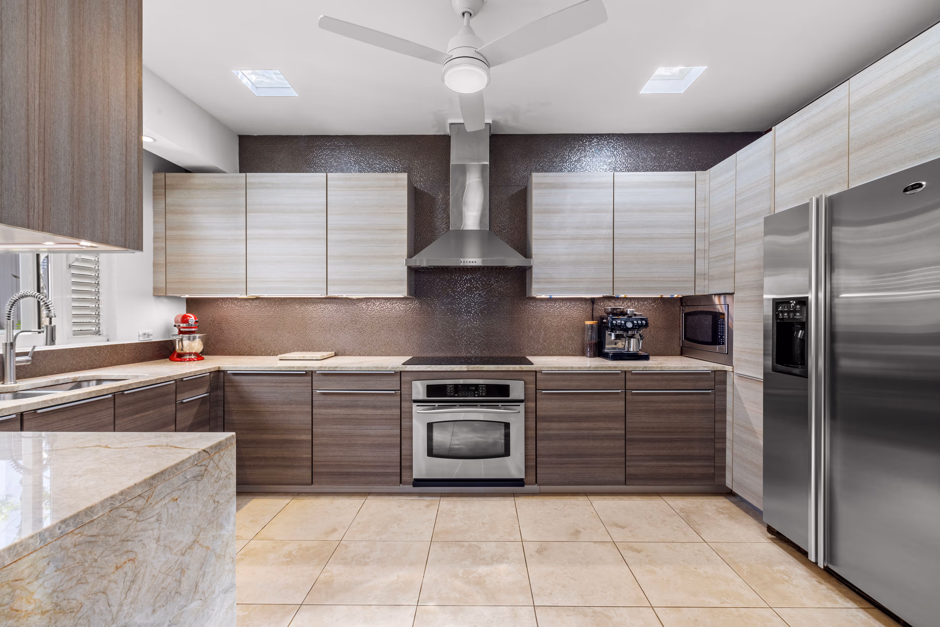 High-end kitchen with sleek cabinetry, stainless steel appliances, and a stylish backsplash in a luxury home in Villas Reales, Guaynabo.