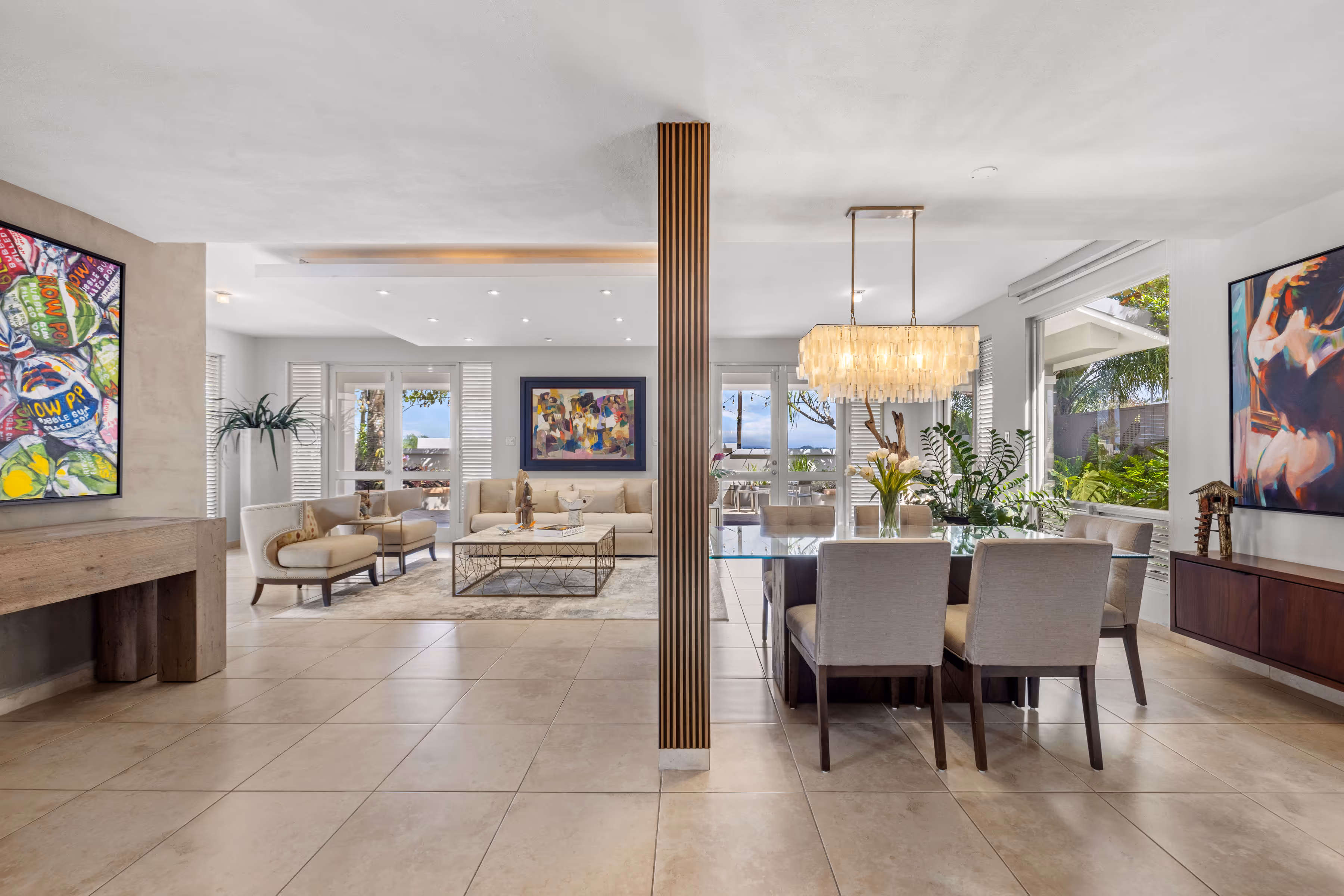 Elegant open-concept living and dining area in a Villas Reales residence, featuring modern furnishings, artistic decor, and abundant natural light.