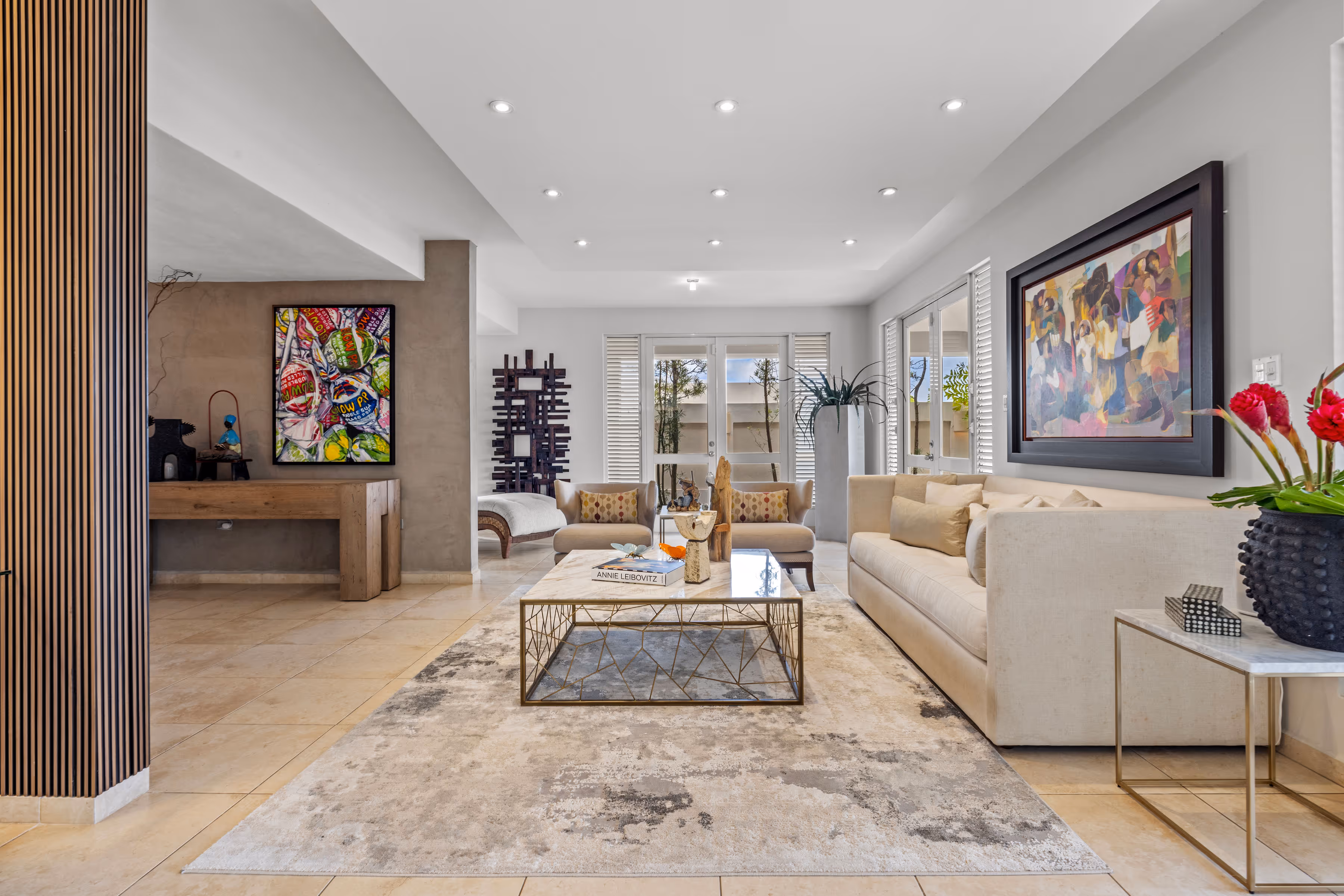 Sophisticated living room with neutral tones, custom artwork, and floor-to-ceiling windows in a luxury home in Villas Reales, Guaynabo.