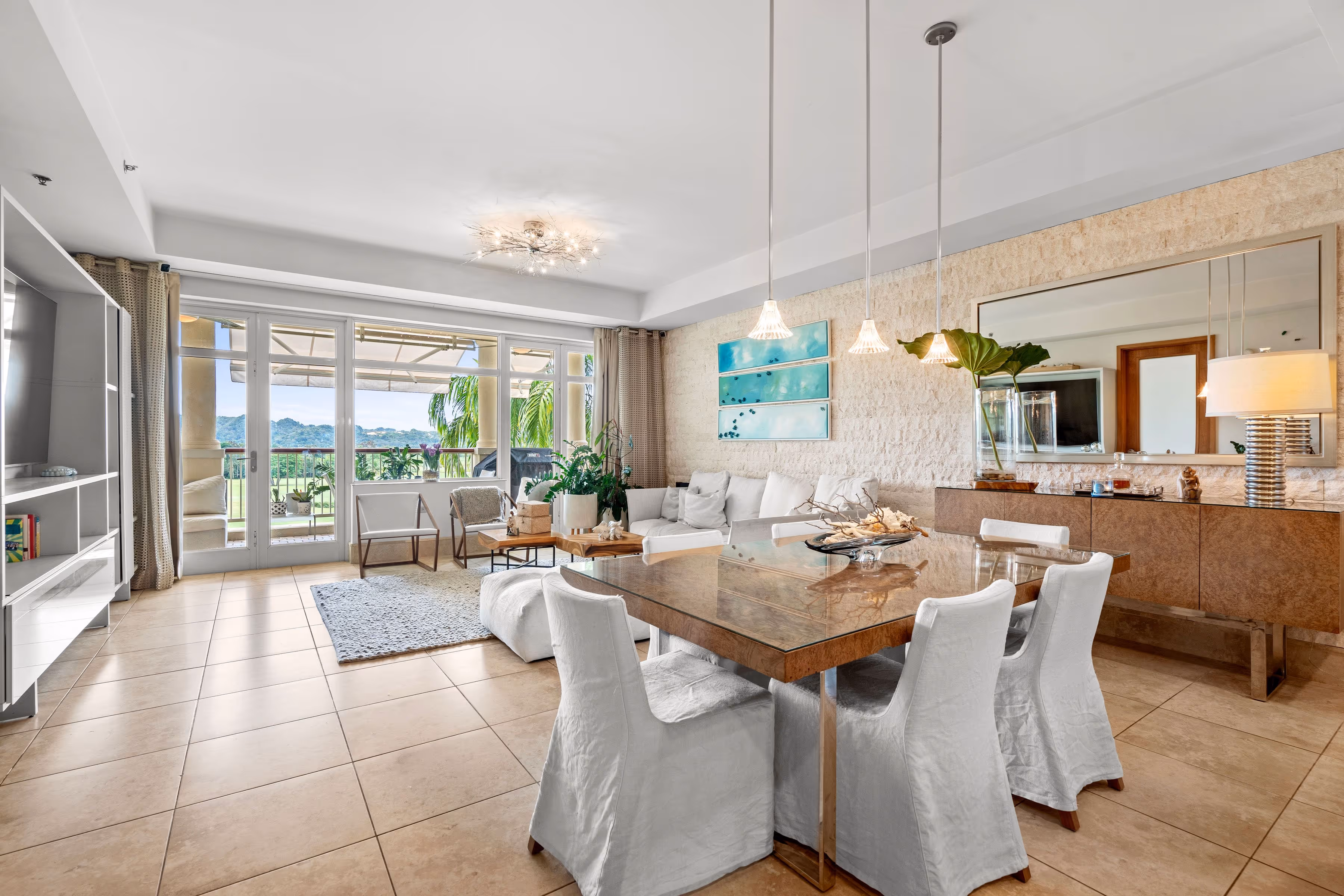 Bright dining area with stylish chandelier and panoramic views at Plantation Village, Dorado Beach Resort
