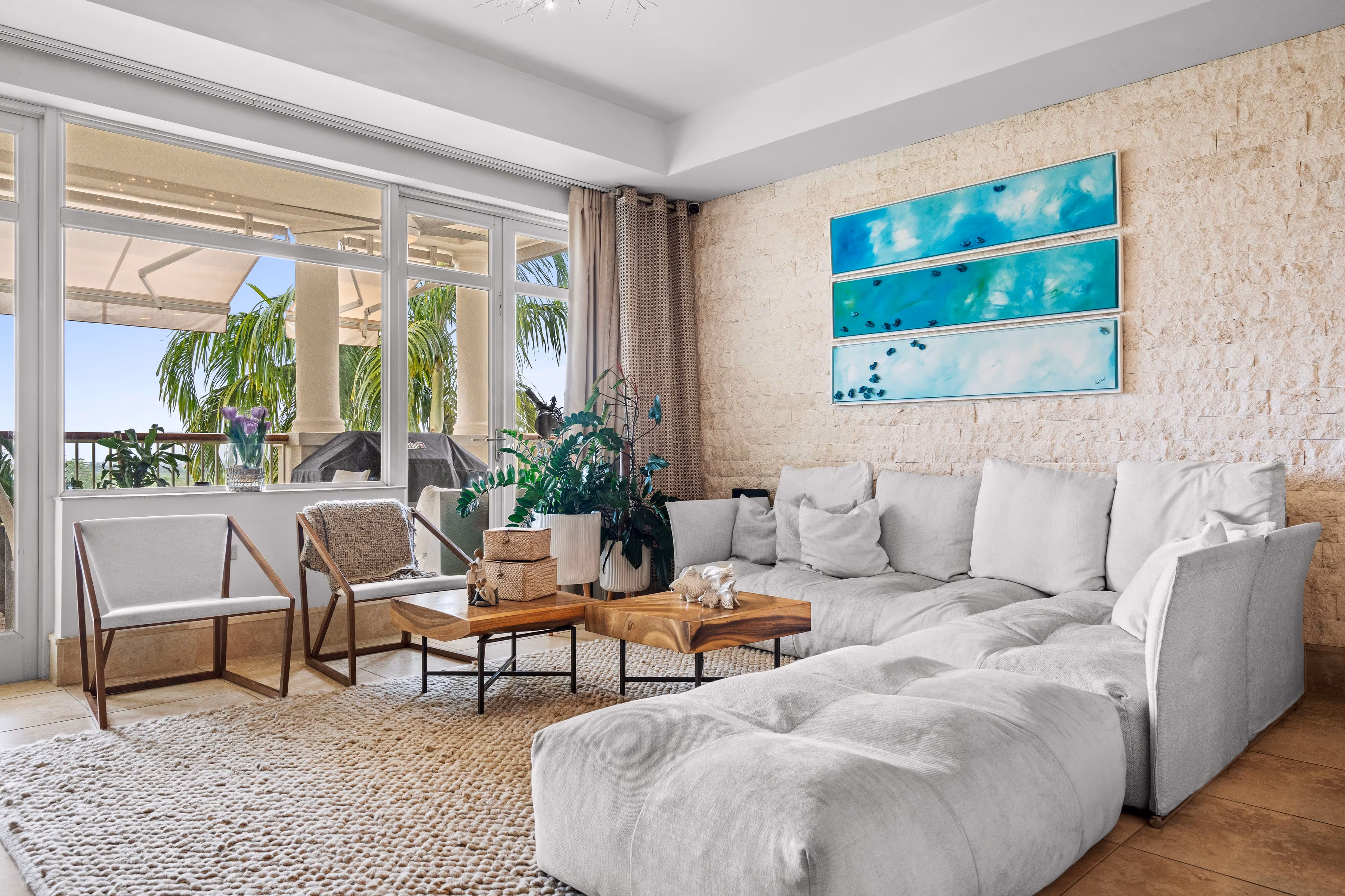 Stylish living room with sectional sofa, contemporary artwork, and natural light at Plantation Village, Dorado Beach Resort