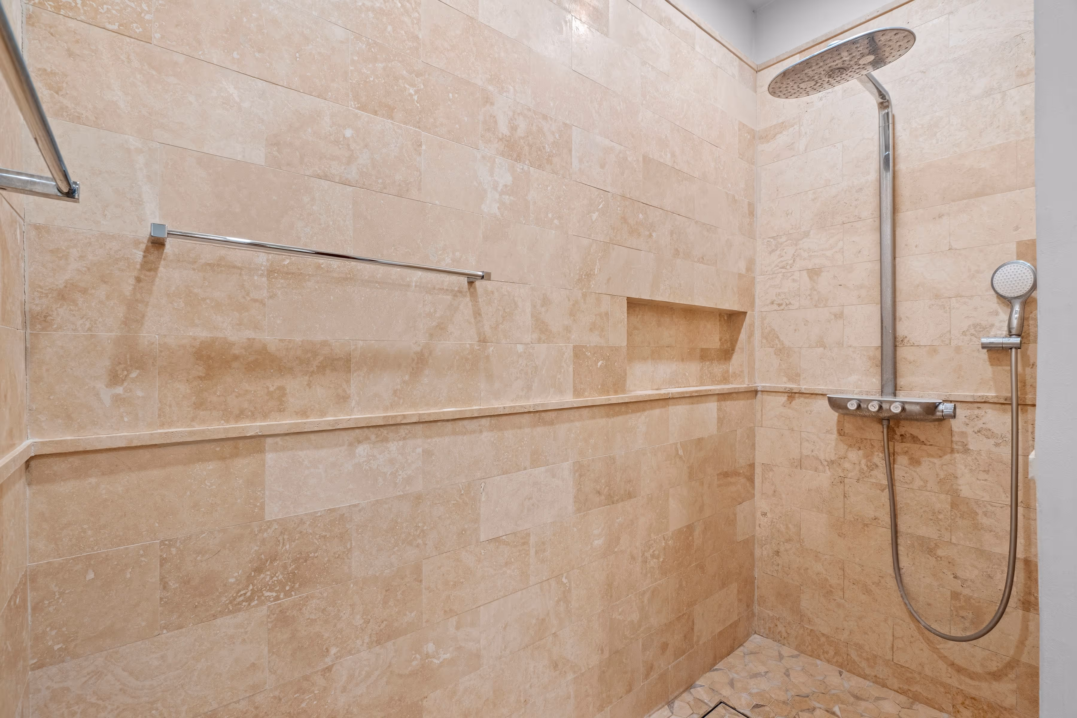 Luxury walk-in shower with polished marble tiles and modern fixtures at Plantation Village, Dorado Beach Resort
