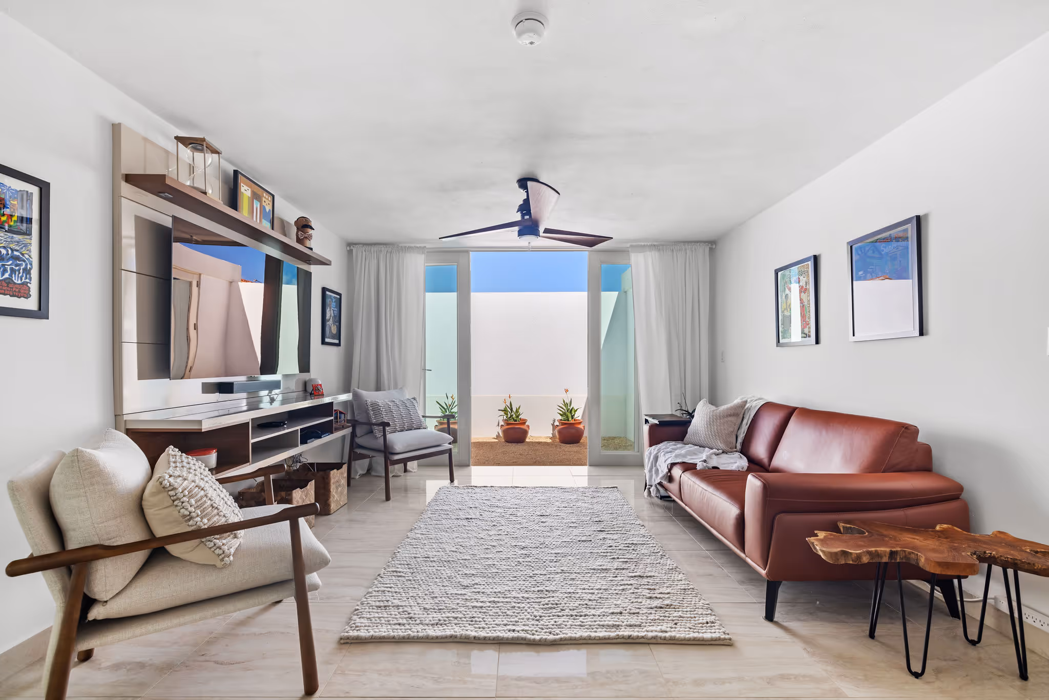 Cozy media room with modern décor and direct outdoor access in sustainable Sabanera Dorado home